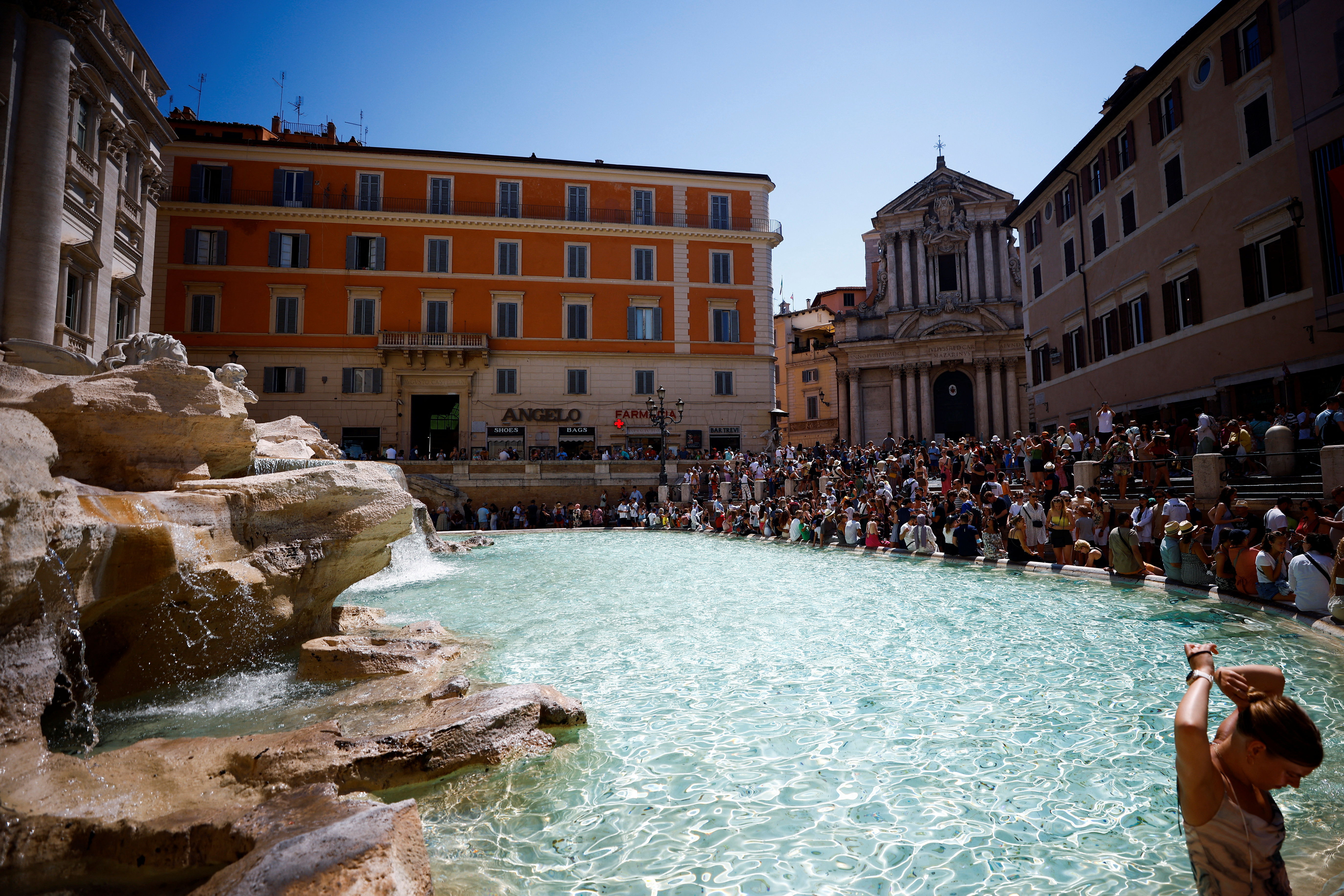 Turistas se refrescan en la Fontana de Trevi, en Roma en medio de las temperaturas récord europeas. (REUTERS/Guglielmo Mangiapane)