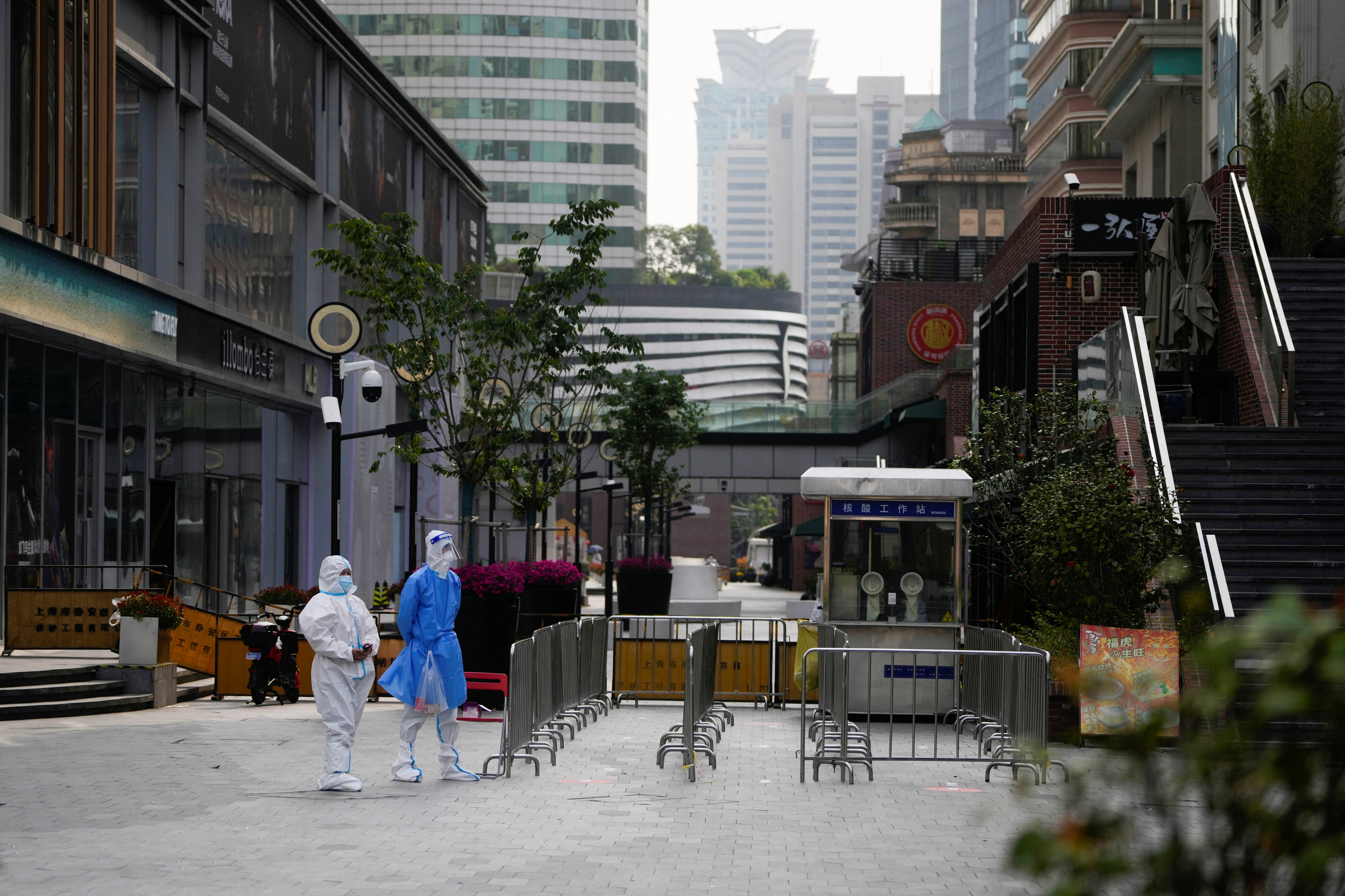 Trabajadores con trajes protectores, parados en una calle durante el cierre, en medio de la pandemia de la enfermedad por coronavirus (COVID-19), en Shanghái, China, el 2 de mayo de 2022. REUTERS/Aly Song
