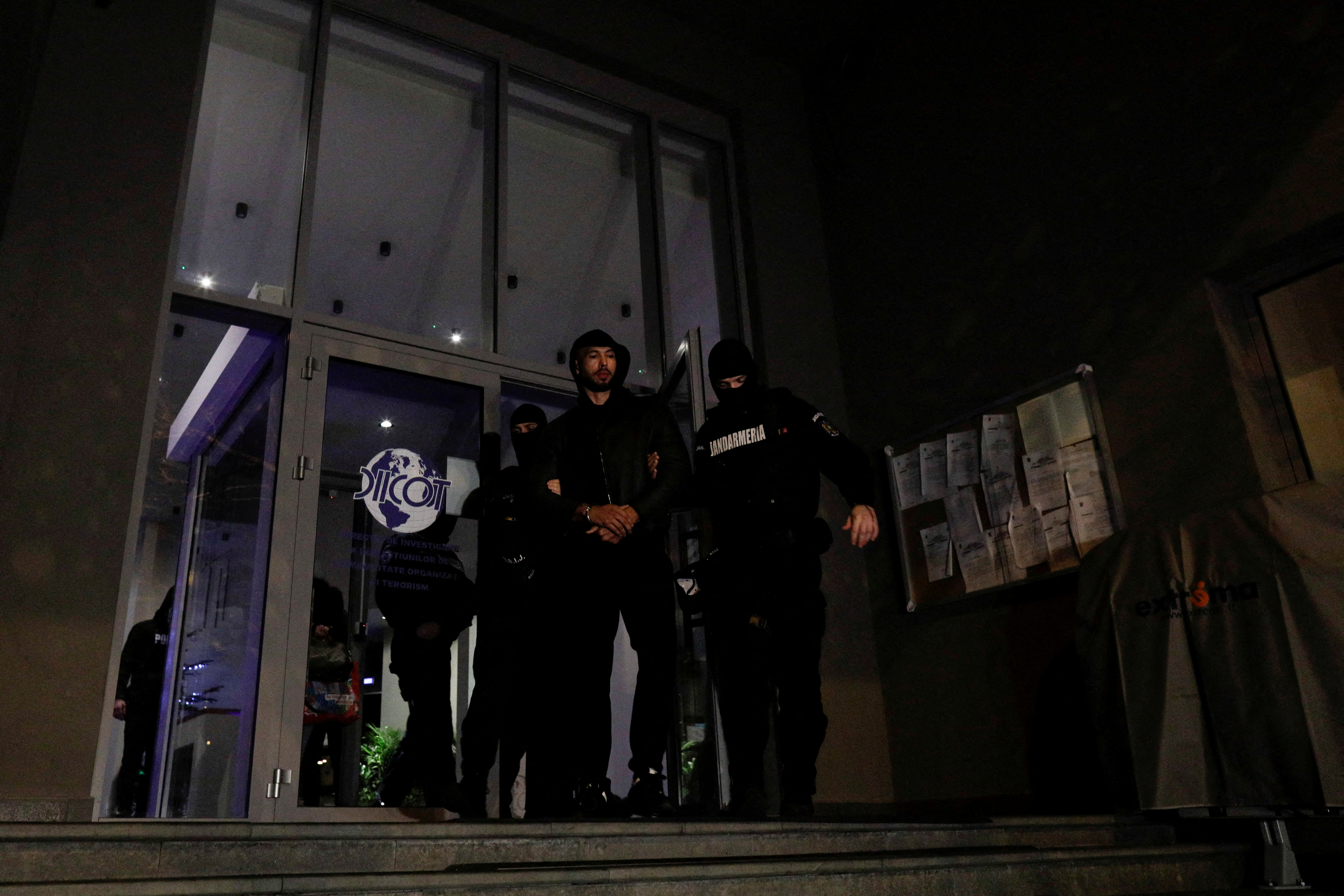Andrew Tate and Tristan Tate are escorted by police officers out of the Bucharest Directorate for Investigation of Organized Crime and Terrorism (DIICOT) headquarters after being detained, in Bucharest, Romania December 29, 2022. Inquam Photos/Octav Ganea via REUTERS/File