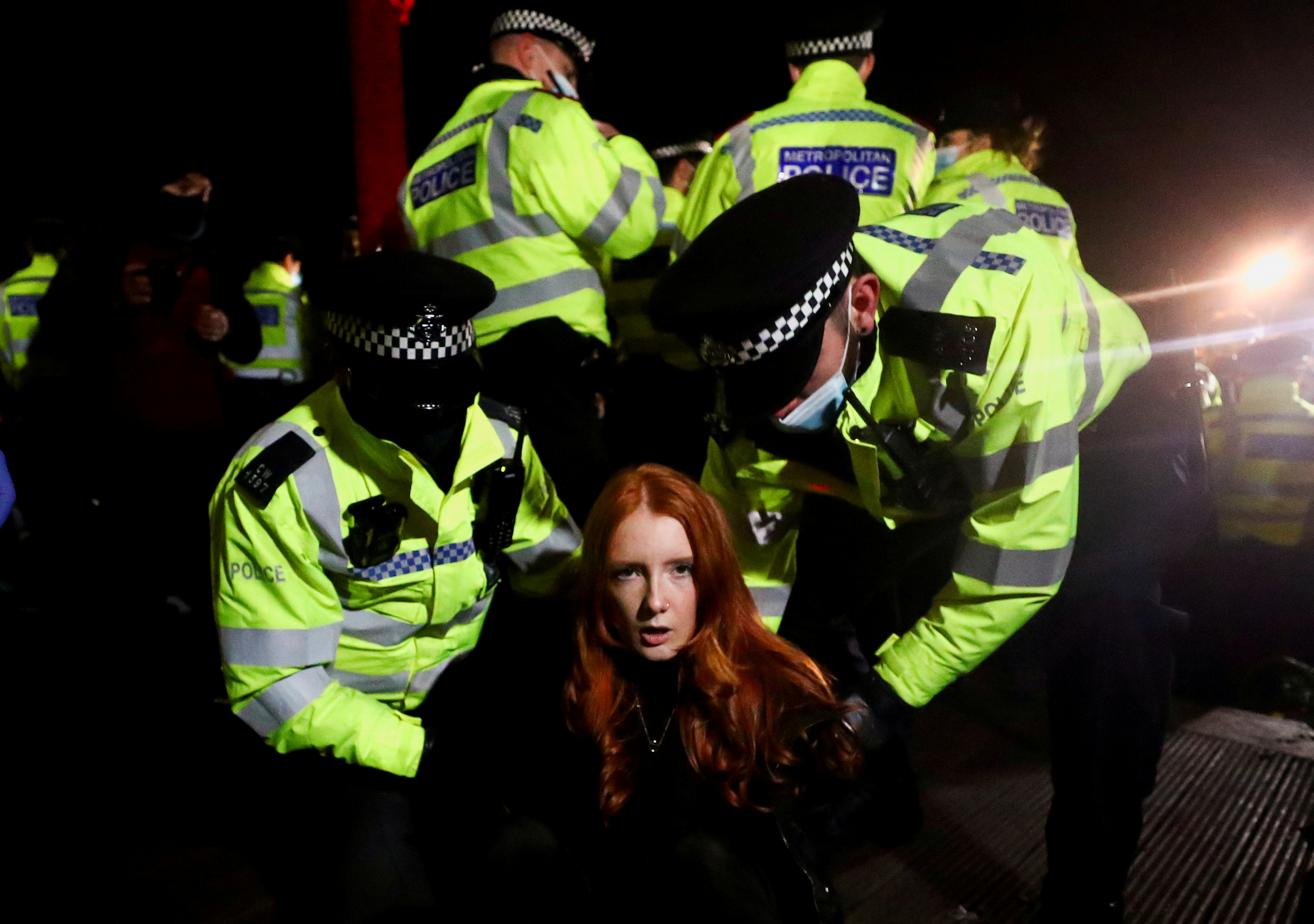 Police detain a woman as people gather at a memorial site in Clapham Common Bandstand, following the kidnap and murder of Sarah Everard, in London, Britain March 13, 2021. Reuters photographer Hannah McKay: "This photograph was taken following a vigil for Sarah Everard, a young woman whose kidnap and murder by a serving police officer in London a few days earlier unleashed a wave of revulsion in the United Kingdom. It shows a lone female protester, student Patsy Stevenson, being carted off by male police officers. It became an image that captured the national mood of anger at the insecurity women face in the United Kingdom and around the world. I had spent the day on Clapham Common where hundreds of people formed a ring around the bandstand where a minute's silence was held. As a small group of protestors began addressing the crowd, the police immediately arrived to break up the vigil due to coronavirus restrictions. As it got dark the atmosphere changed, going from a reflective emotional mood to a more angry one. Patsy was one of the last remaining people on the bandstand and was restrained face down on the floor with her hands behind her back. It was dark, there was lots of shouting and she was clearly distressed. This picture of her on the floor was taken minutes later once the situation had calmed slightly. I continued to shoot for another hour. It was only when I got home, looked at Twitter and saw the reactions to the protest that I realised how important that image had become. Within days the London police faced backlash for how they broke up the vigil and Everard's murder resonated with women around the world who have experienced violence and sexual assaults."   REUTERS/Hannah McKay/File Photo    SEARCH "POY STORIES 2021" FOR THIS STORY. SEARCH "WIDER IMAGE" FOR ALL STORIES   TPX IMAGES OF THE DAY