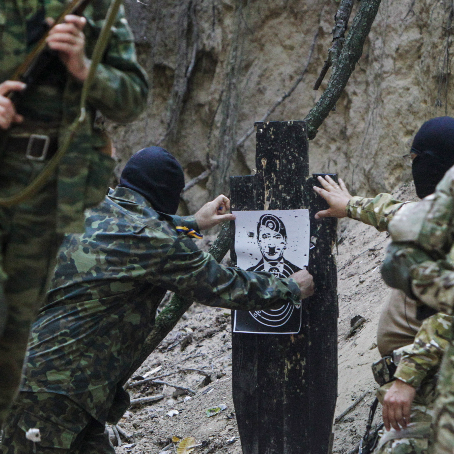 Partisanos ucranianos de Zaporizhzhia practican tiro con una imagen de Putin caracterizado como Hitler. (Telegram)