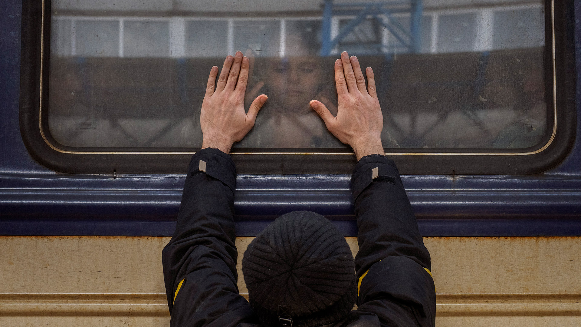 Aleksander, de 41 años, apoya las palmas de sus manos contra la ventana mientras se despide de su hija Anna, de 5 años, que se encuentra a bordo de un tren a Lviv en la estación de Kiev, Ucrania, el viernes 4 de marzo de 2022. Aleksander tiene que quedarse para combatir en la guerra, mientras su familia sale del país para buscar refugio  (AP Photo/Emilio Morenatti)