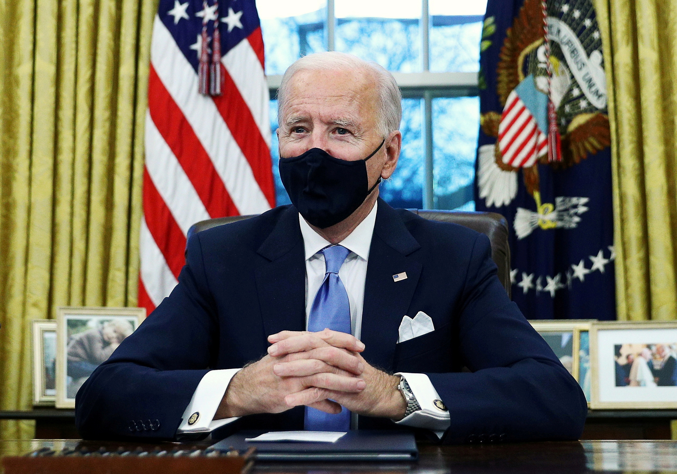 El presidente de Estados Unidos, Joe Biden, firma órdenes ejecutivas en el Despacho Oval de la Casa Blanca en Washington, en su primer día en el cargo, el 20 de enero de 2021. REUTERS/Tom Brenner