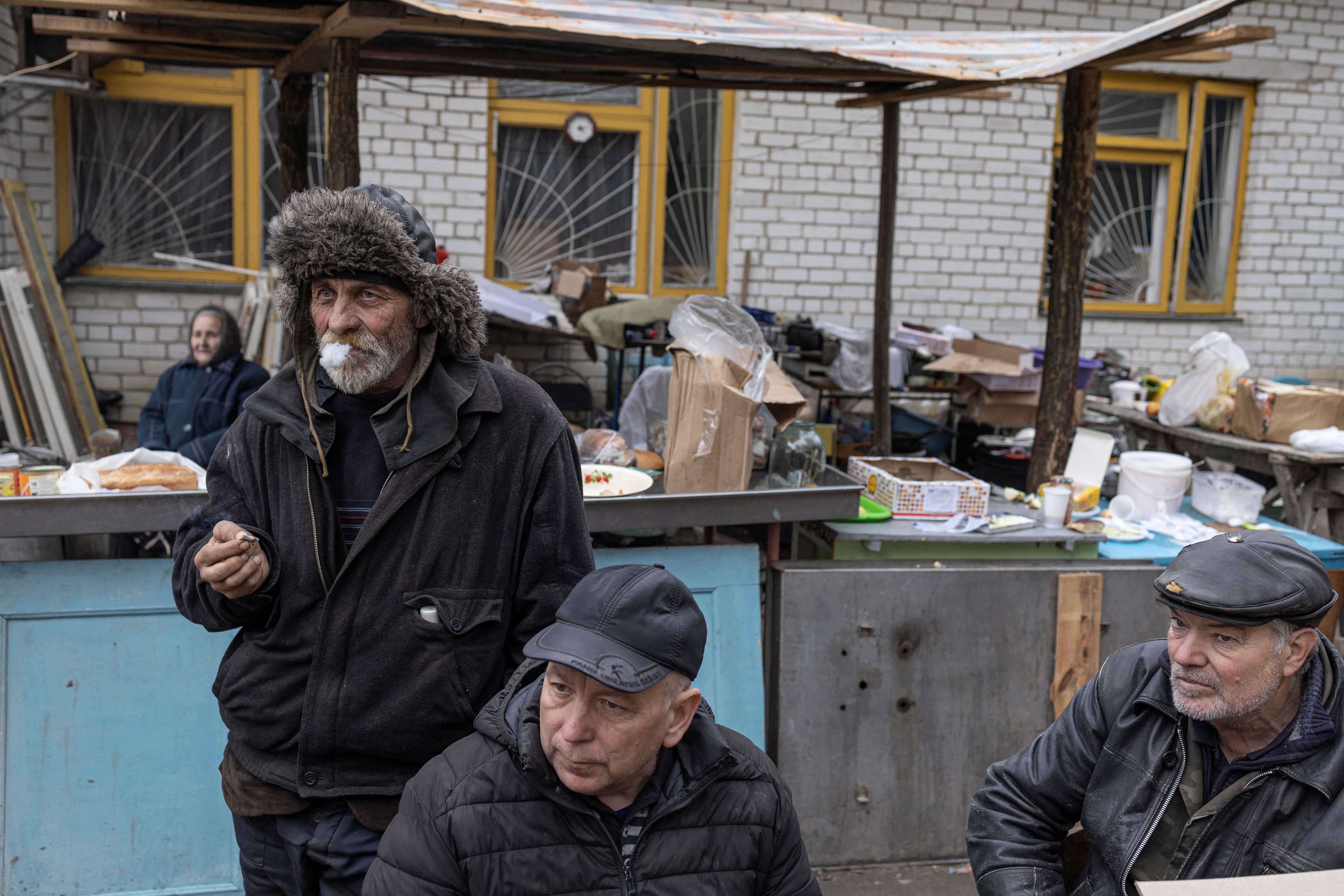 Ivan Balanovych fuma un cigarrillo con sus amigos frente a una escuela dañada, mientras continúa la invasión rusa de Ucrania, en el pueblo de Yahidne, cerca de Chernihiv, Ucrania, 6 de abril de 2022. REUTERS/Marko Djurica 