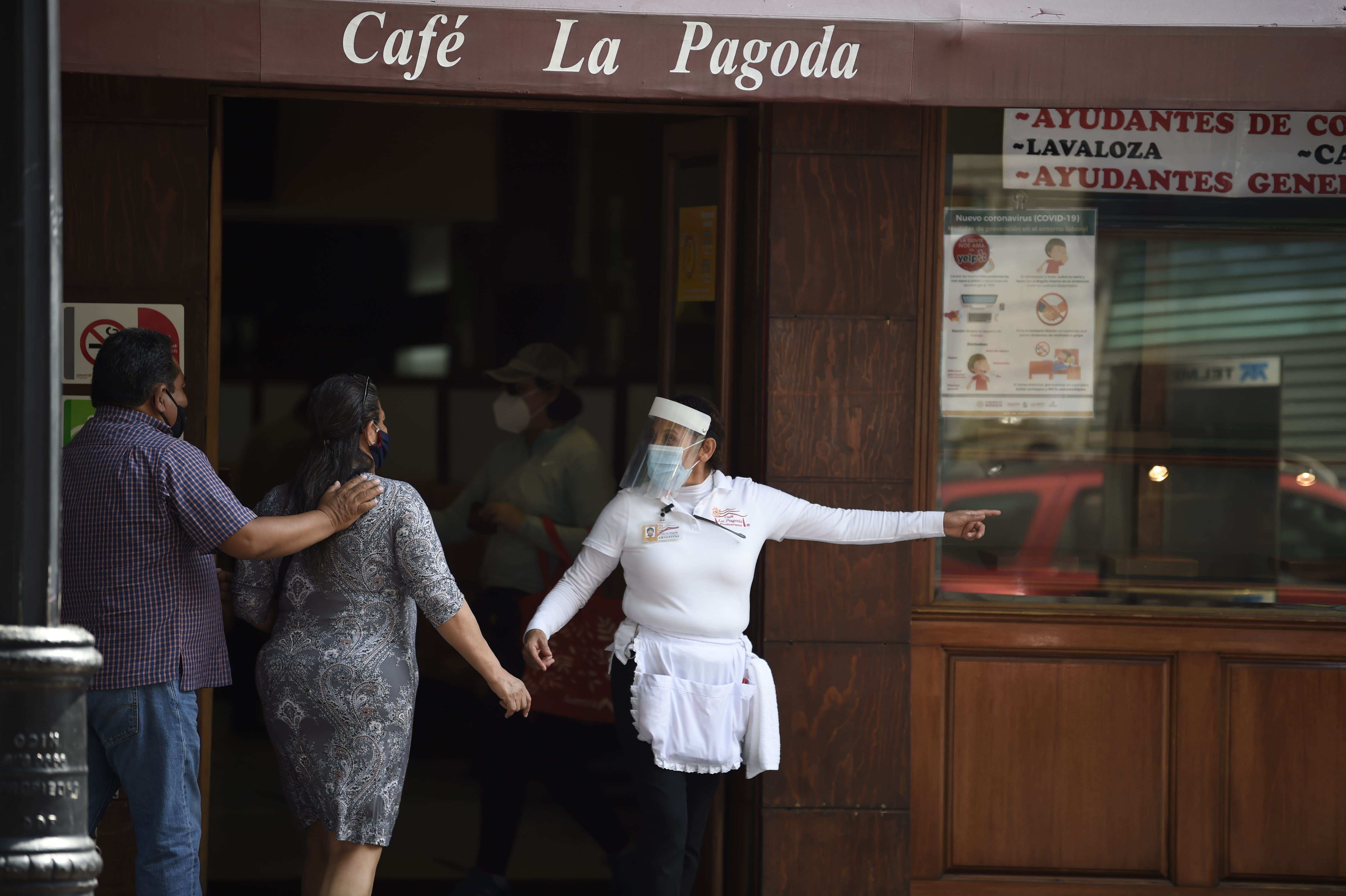 Un empleado de un restaurante interactúa con clientes en la Ciudad de México el 1 de julio de 2020 durante la pandemia COVID-19. (Foto: Alfredo ESTRELLA / AFP)