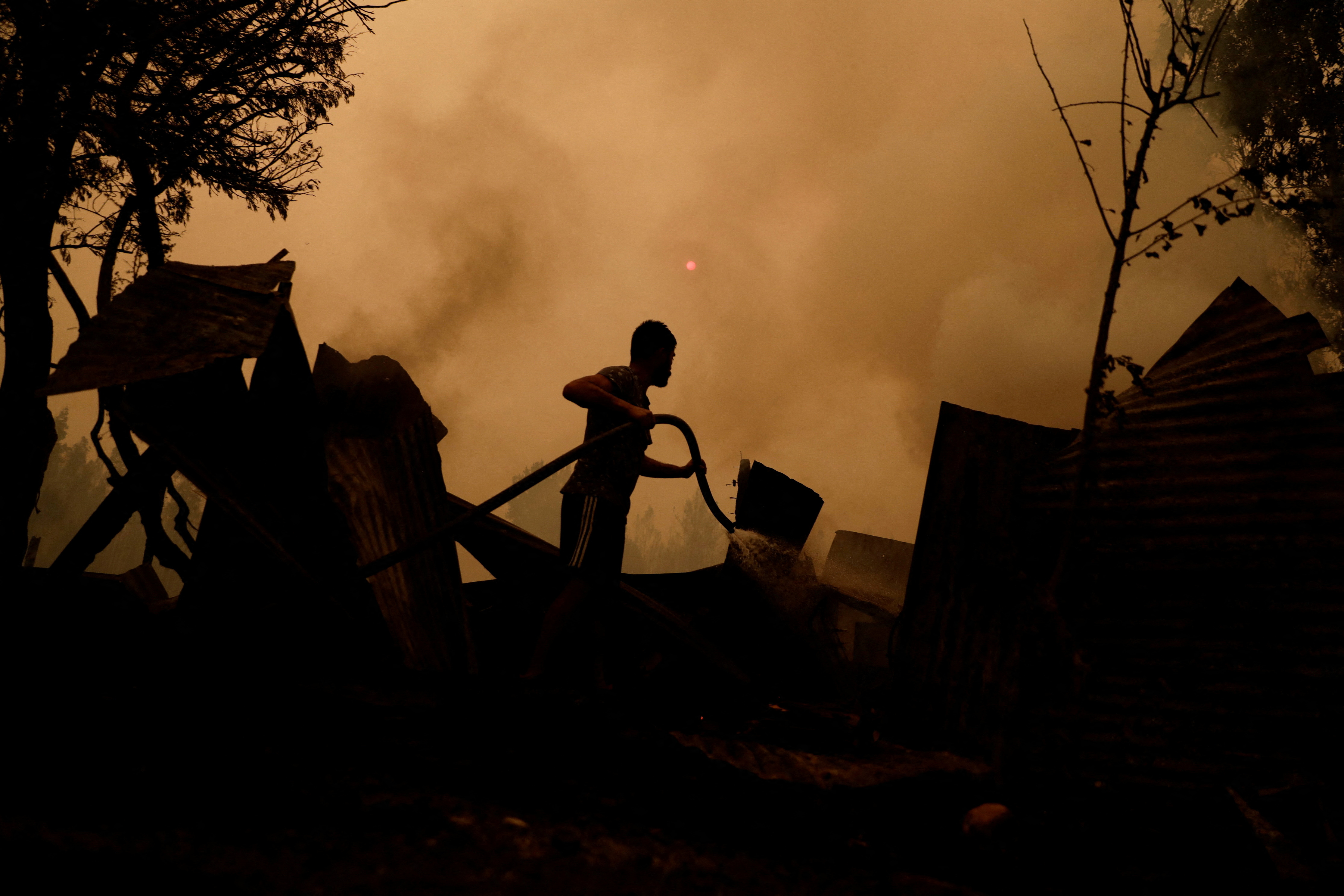 Un residente intenta apagar el fuego durante un incendio forestal en Santa Juana, cerca de Concepción, Chile, 3 de febrero de 2023. REUTERS/Juan Gonzalez