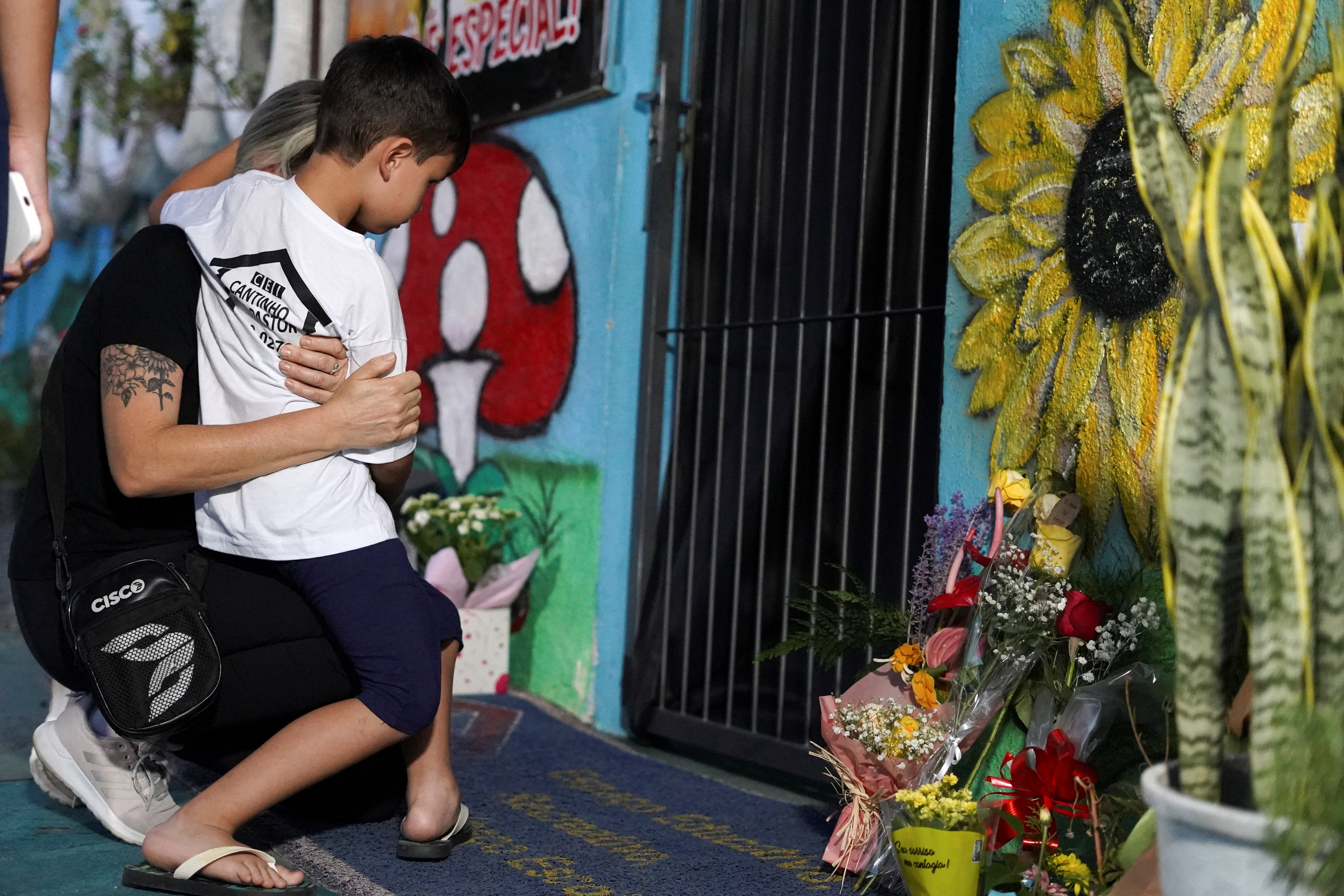 Una familia reza durante un homenaje a las víctimas de un atentado mortal en la guardería Cantinho do Bom Pastor, en Blumenau, Santa Catarina, Brasil, el 5 de abril de 2023 (REUTERS/Vinicius Bretzke)