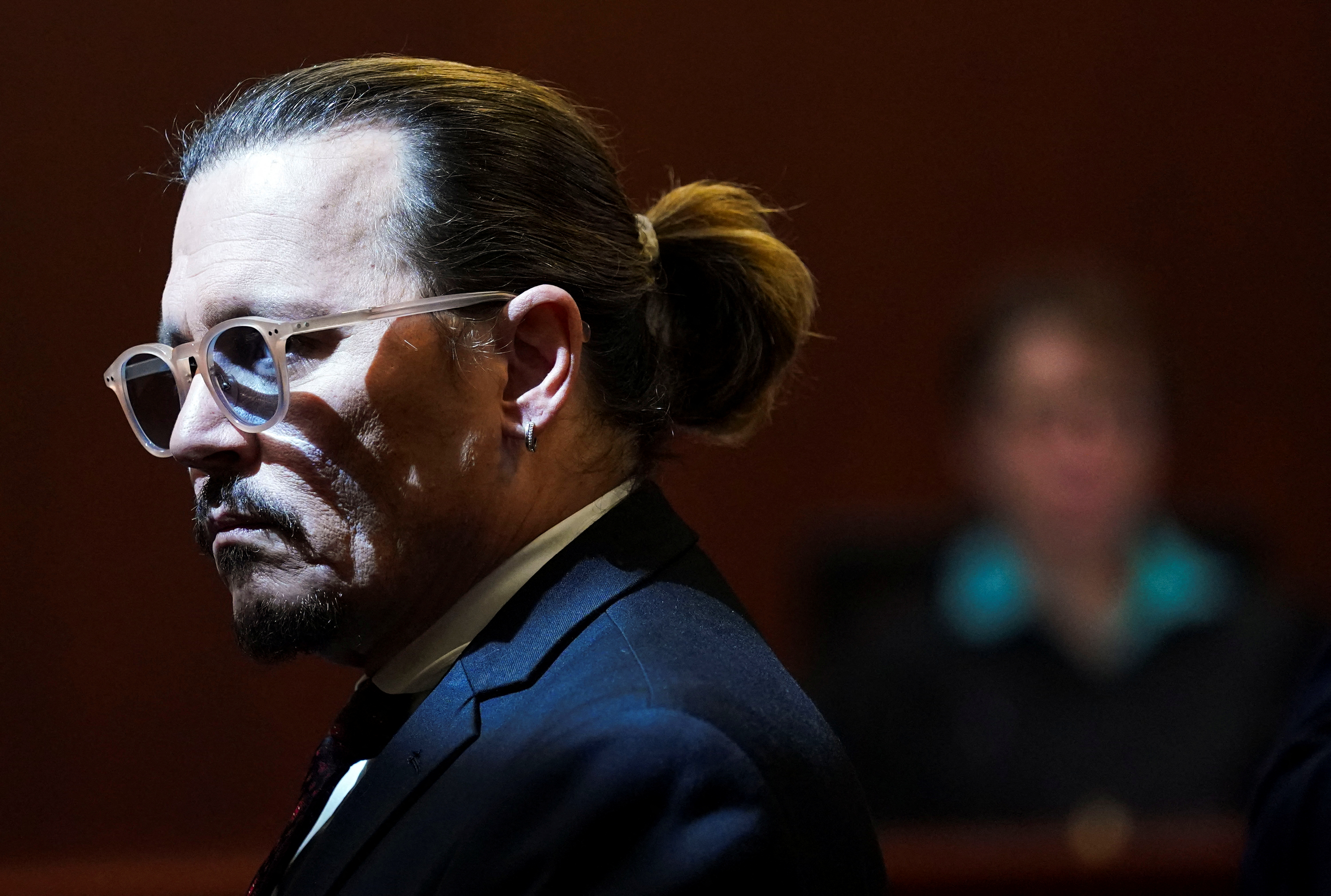 Johnny Depp se levanta durante un receso en el juicio por difamación contra su exesposa Amber Heard en el Tribunal de Circuito del Condado de Fairfax, Virginia, Estados Unidos (Reuters)
