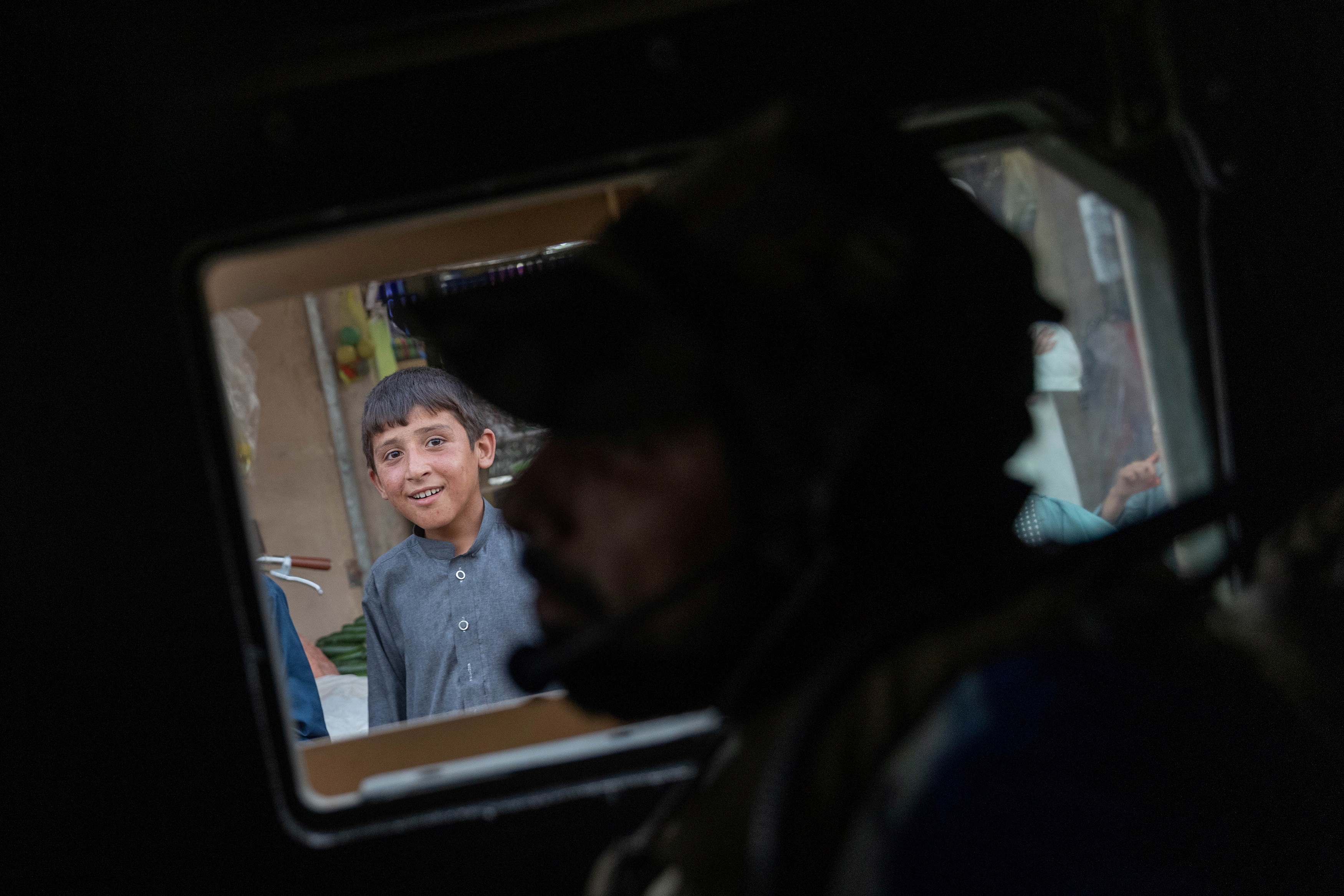 Un niño observa cómo el convoy de las fuerzas especiales afganas pasa por un mercado durante una misión de combate contra los talibanes, en la provincia de Kandahar, Afganistán, el 12 de julio de 2021. Foto tomada el 12 de julio de 2021. 