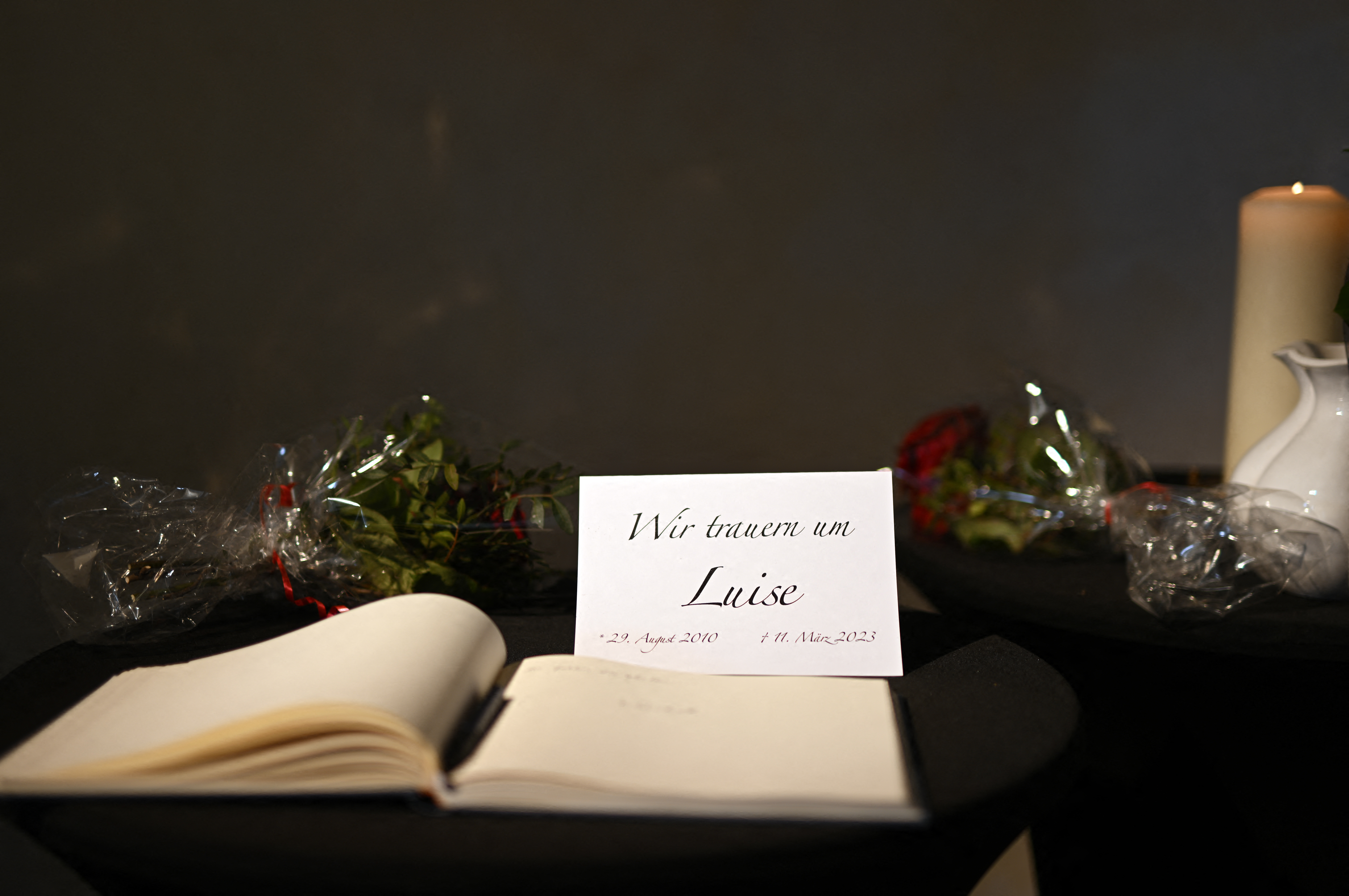 El libro de condolencias por la niña asesinada Luise y una tarjeta en la que se lee "Lloramos a Luise" se exponen en la iglesia protestante de Freudenberg, en el oeste de Alemania, el 15 de marzo de 2023 (AFP)