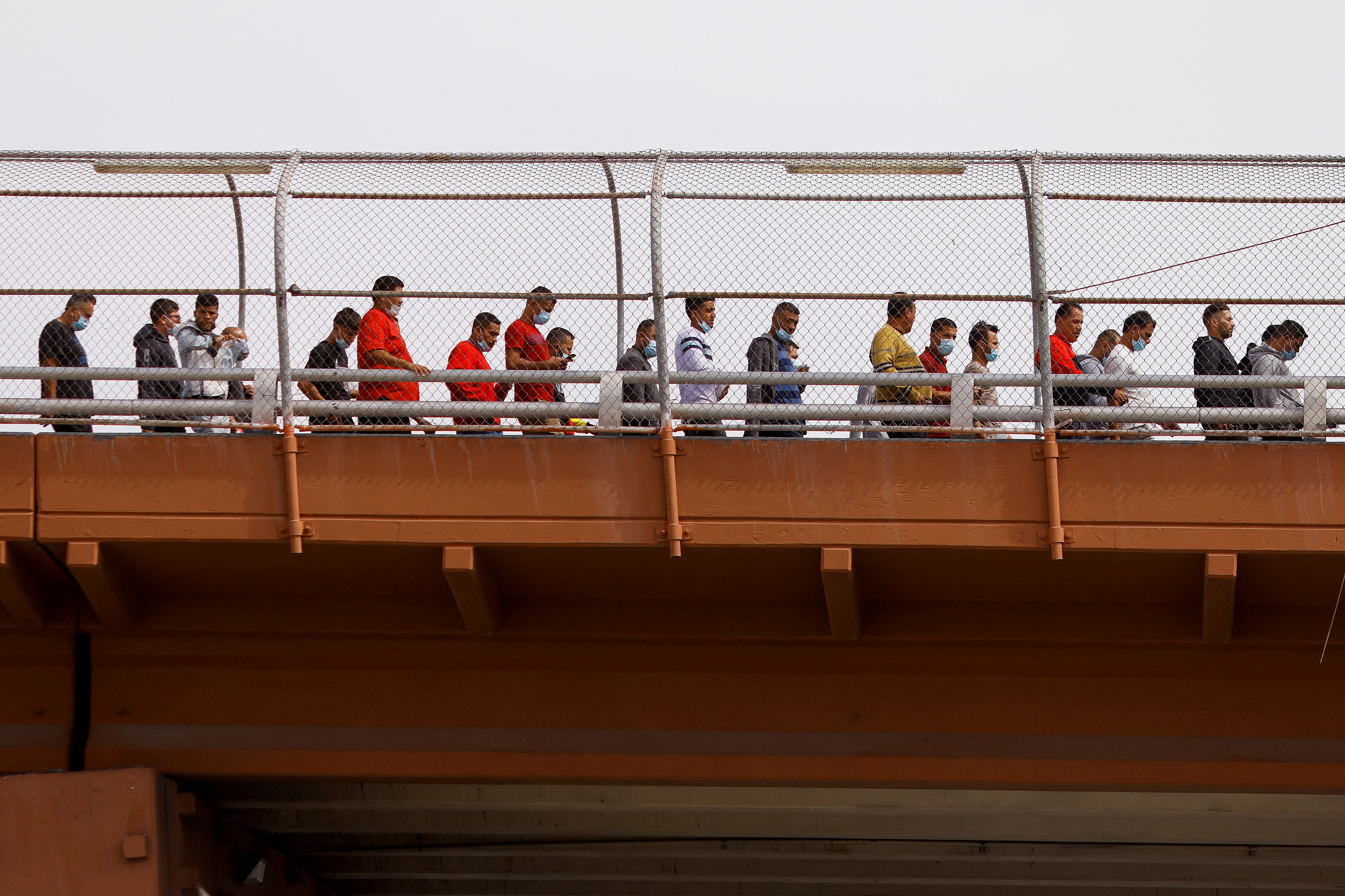 Venezuelan migrants, expelled from the United States and returned to Mexico under Title 42, walk into Mexico across the Lerdo-Stanton international border bridge, in this image taken from Ciudad Juarez, Mexico on October 14, 2022. REUTERS/Jose Luis Gonzalez