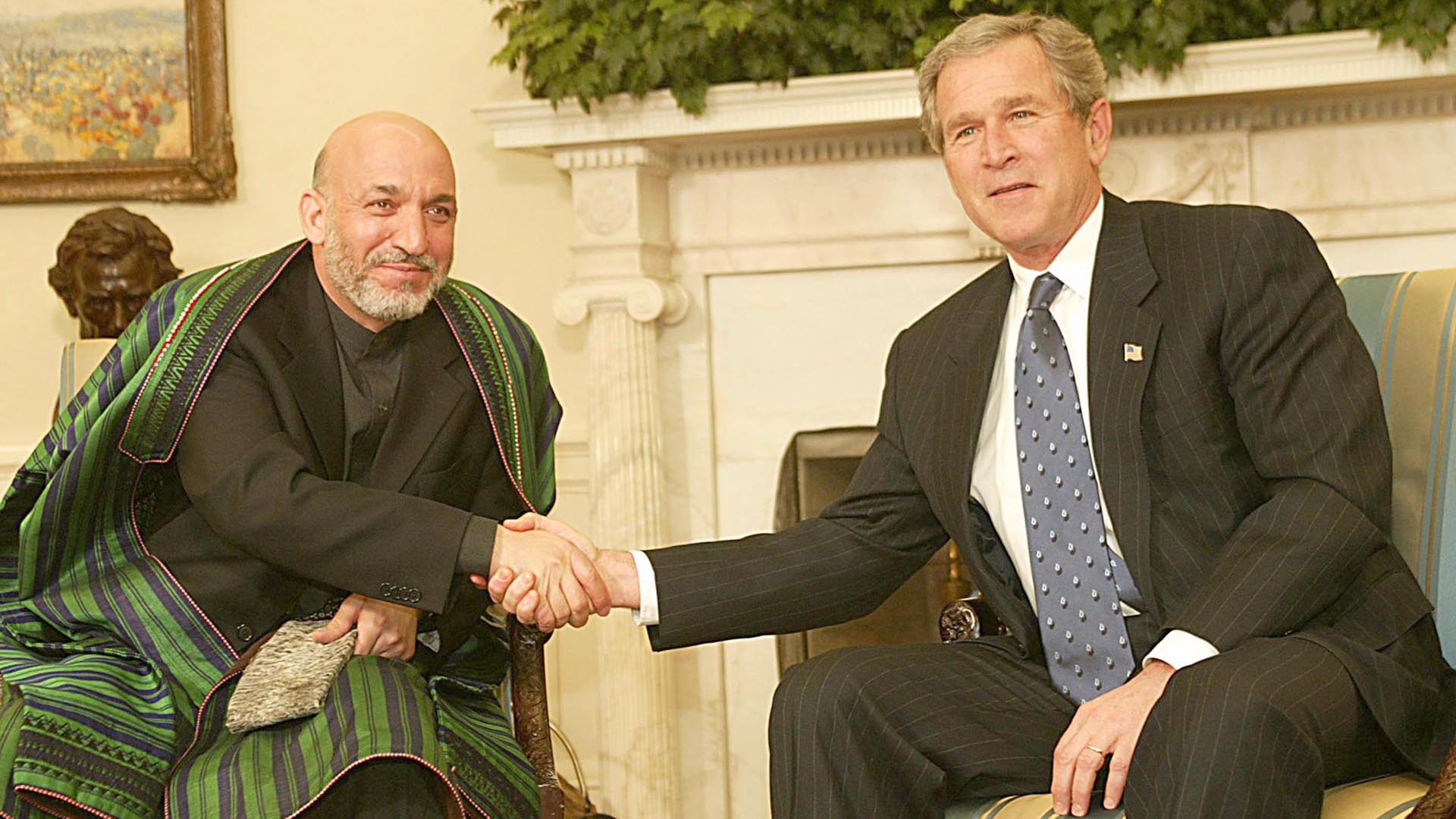 El presidente de Estados Unidos, George W. Bush (R), le da la mano al presidente de Afganistán, Hamid Karzai, en la Oficina Oval de la Casa Blanca en Washington, DC, el 27 de febrero de 2003. (AFP/ Luke FRAZZA)