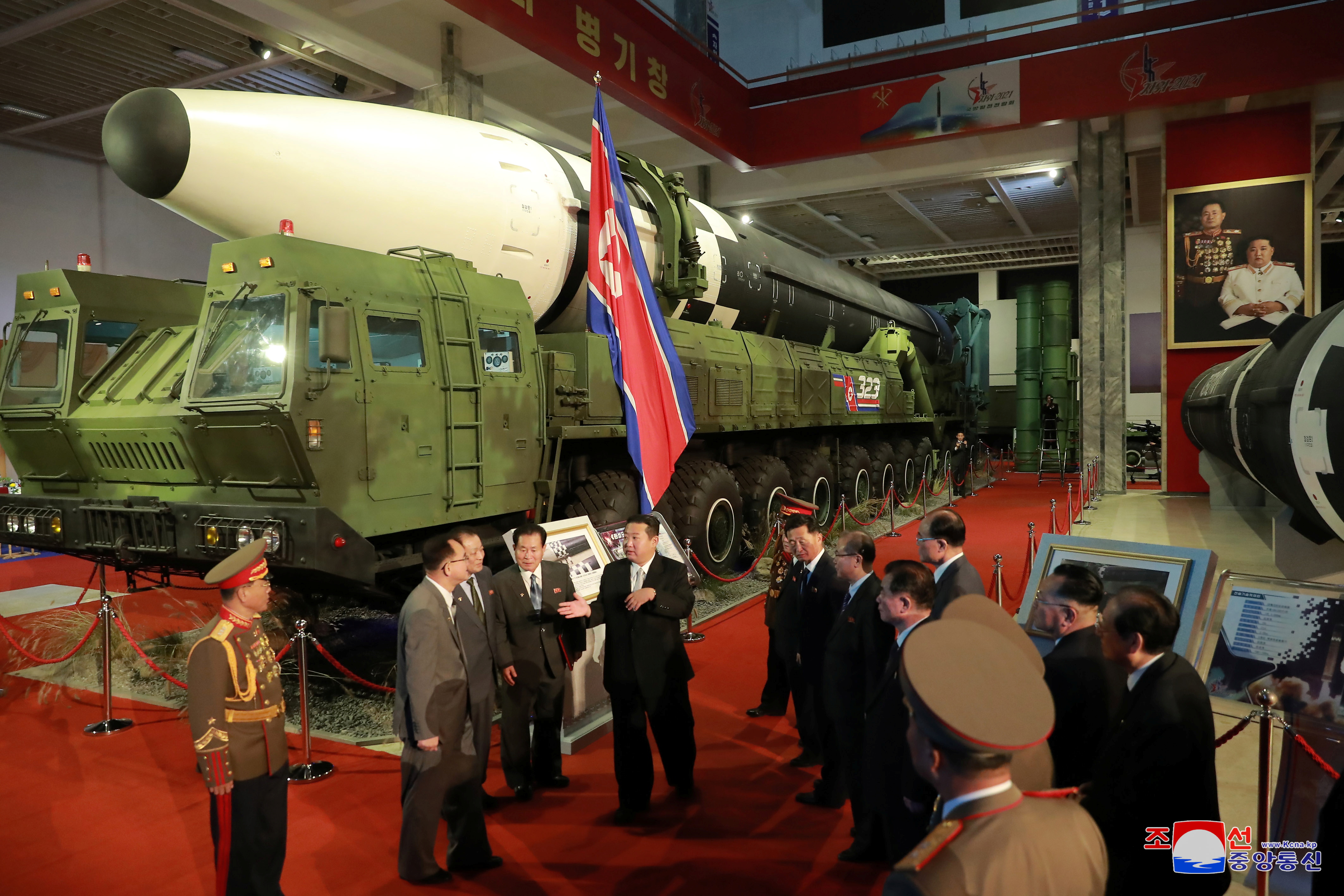 El líder de Corea del Norte, Kim Jong Un, habla con funcionarios junto a armas y vehículos militares expuestos, incluidos los misiles balísticos intercontinentales (ICBM) del país, en la Exposición de Desarrollo de Defensa, en Pyongyang, Corea del Norte, en esta foto sin fecha publicada el 12 de octubre de 2021 por la Agencia Central de Noticias de Corea del Norte (KCNA).   KCNA via REUTERS   