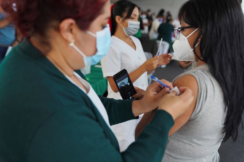 Imagen de archivo.  Una mujer se toma una selfi mientras recibe una dosis de la vacuna contra el COVID-19 Sputnik V, en Ciudad de México, México.  27 de julio de 2021. REUTERS/Toya Sarno Jordania