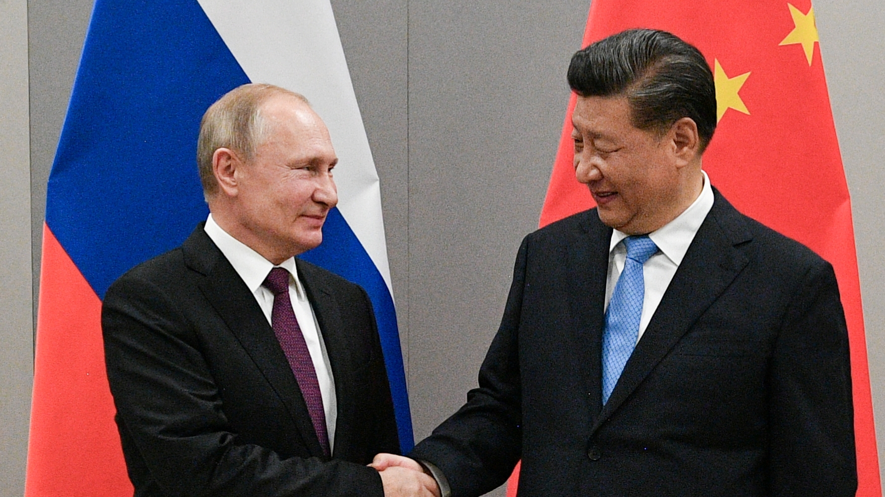 Vladimir Putin estrecha su mano a  Xi Jinping durante la cumbre de los BRICS en Brasilia