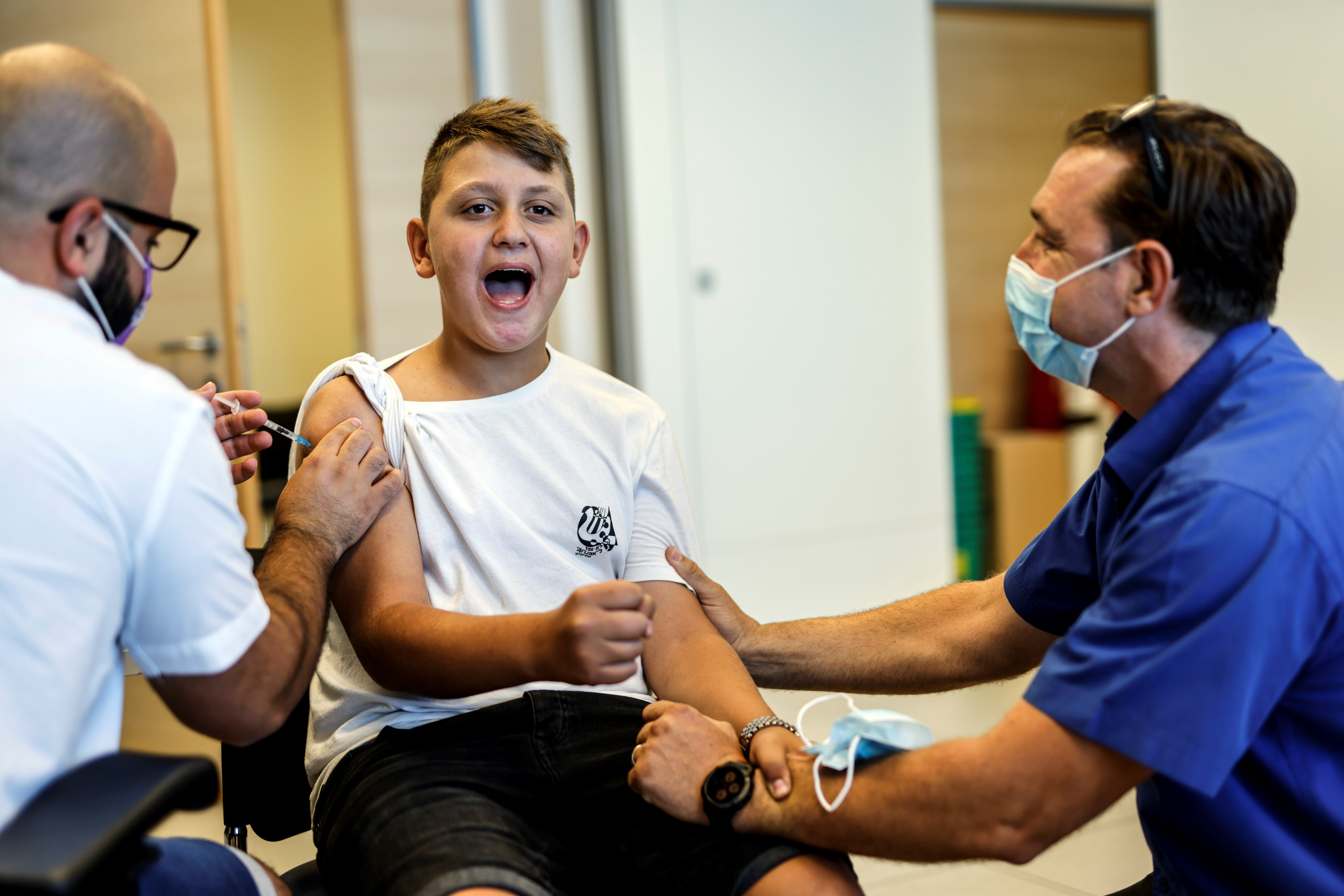 Un chico recibe la primera dosis de la vacuna contra el COVID-19, después de que Israel aprobara su uso para jóvenes de 12 a 15 años (REUTERS/Amir Cohen)