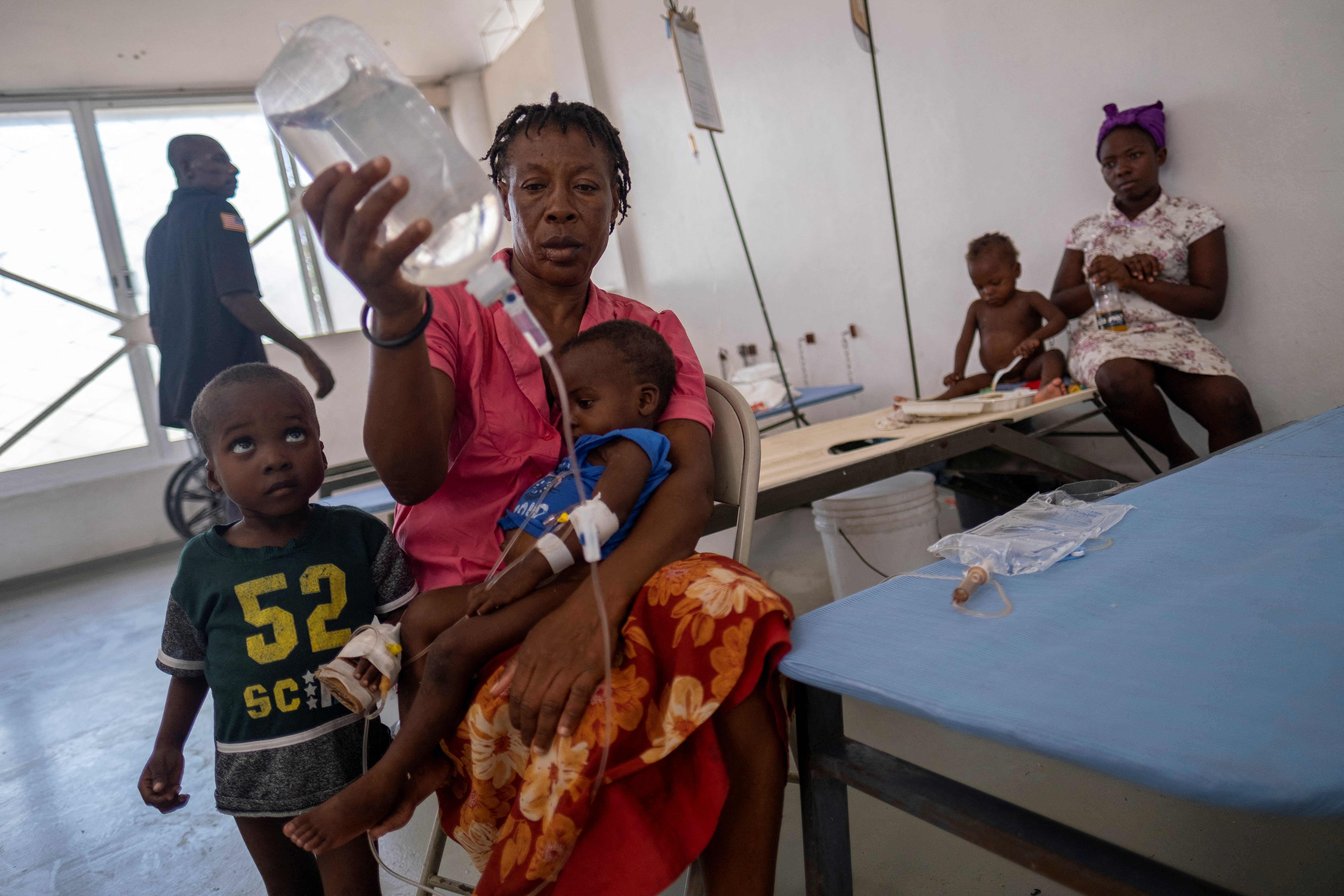 Etienne Lionesse holds a bag of intravenous solutions for her son as he receives treatment for cholera at the UNICEF-supported Gheskio Center hospital in Port-au-Prince, Haiti, on October 14, 2022.  REUTERS/Ricardo Arduengo/File