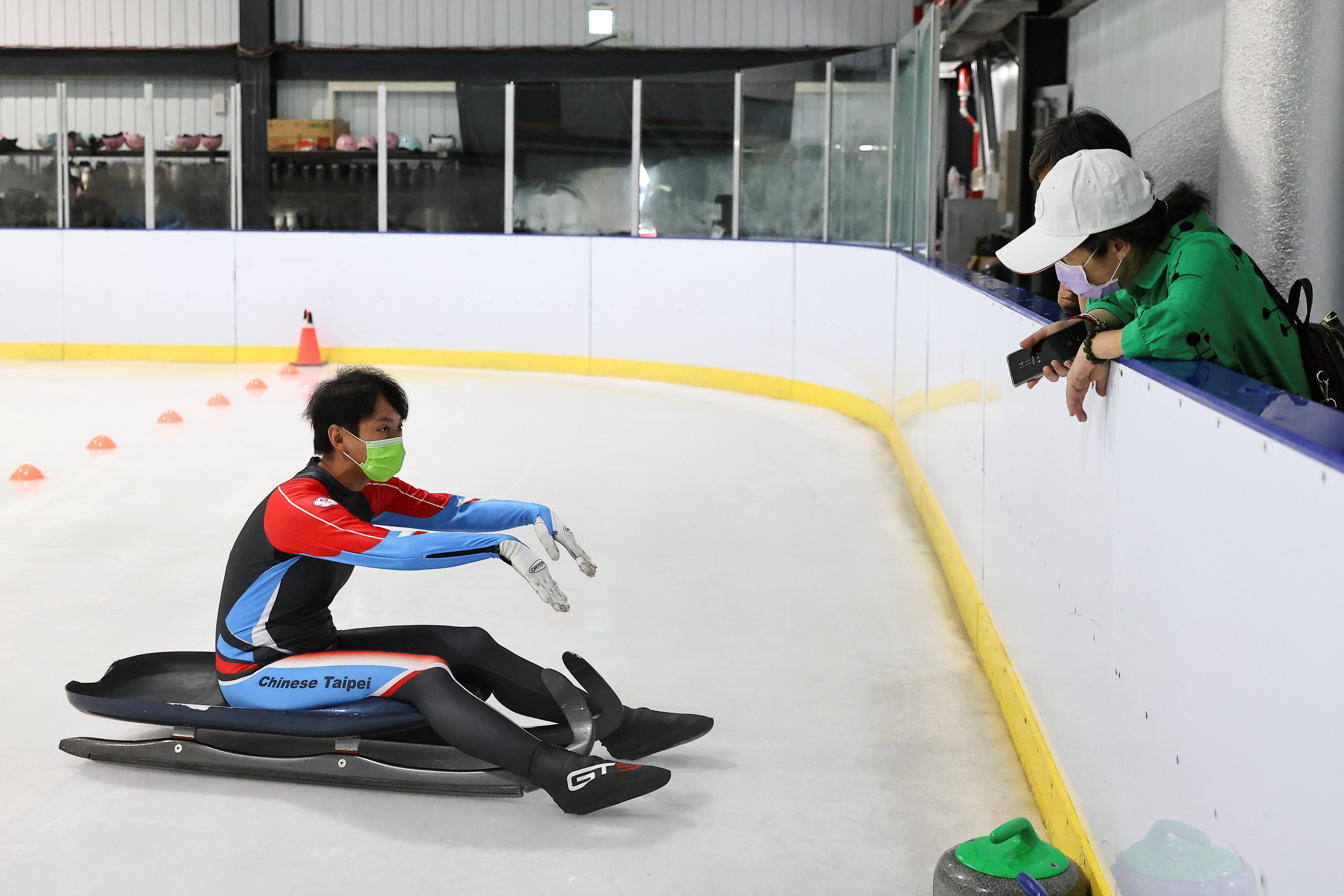 Li Sin-rong, 23, a Taiwanese luger, shows her gloves to her family and colleagues during a practice session at the ice skating range, as part of her training to qualify for the 2022 Beijing Winter Olympic Games, in Taoyuan, Taiwan October 2, 2021. Picture taken October 2, 2021. REUTERS/Ann Wang