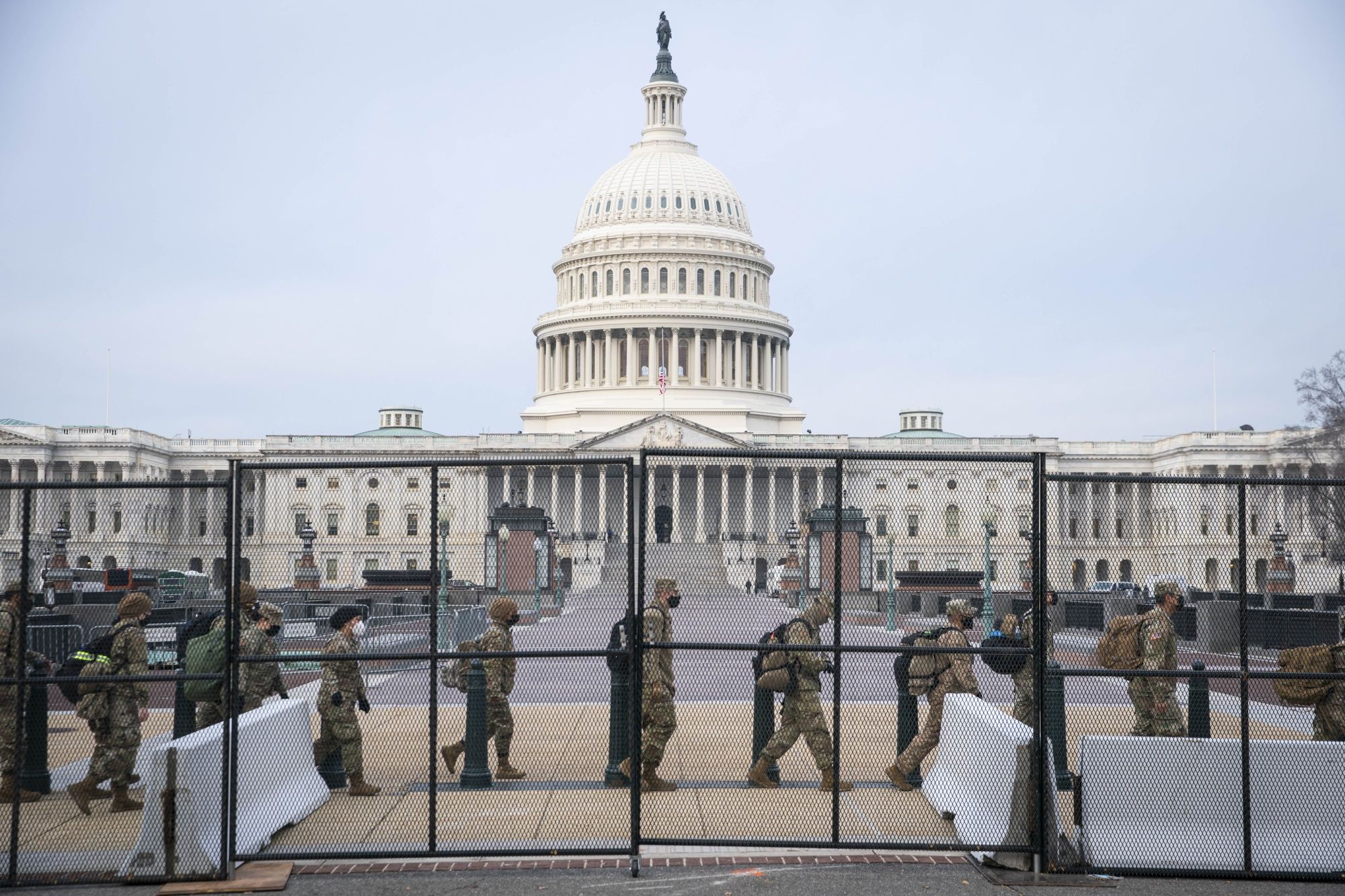 Miembros de la Guardia Nacional caminan detrás de una valla en las inmediaciones del Capitolio de EEUU. Foto: Bloomberg