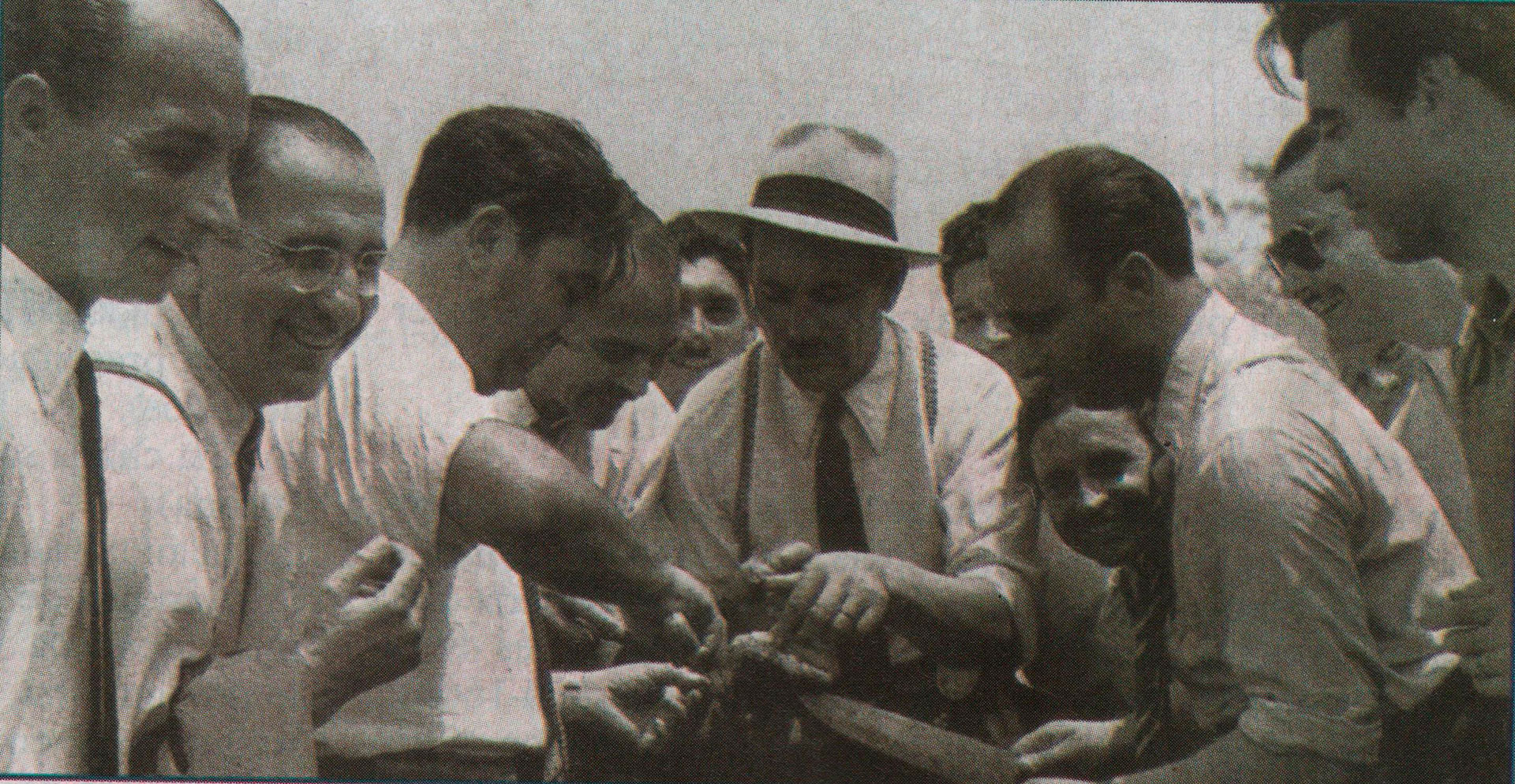 Compartiendo un asado con Fangio, que mete el cuchillo. Pinocho Marimón asoma a la derecha. Otra postal de la Buenos Aires-Caracas (Archivo CORSA)