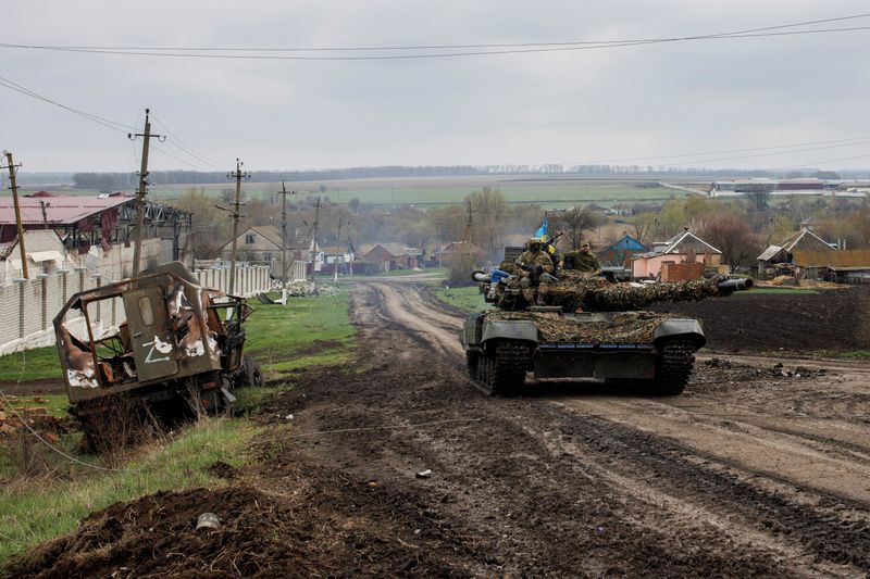 Un tanque ucraniano enviado por la República Checa pasa cerca de un vehículo ruso destruido en la localidad de Husarivka. REUTERS/Alkis Konstantinidis
