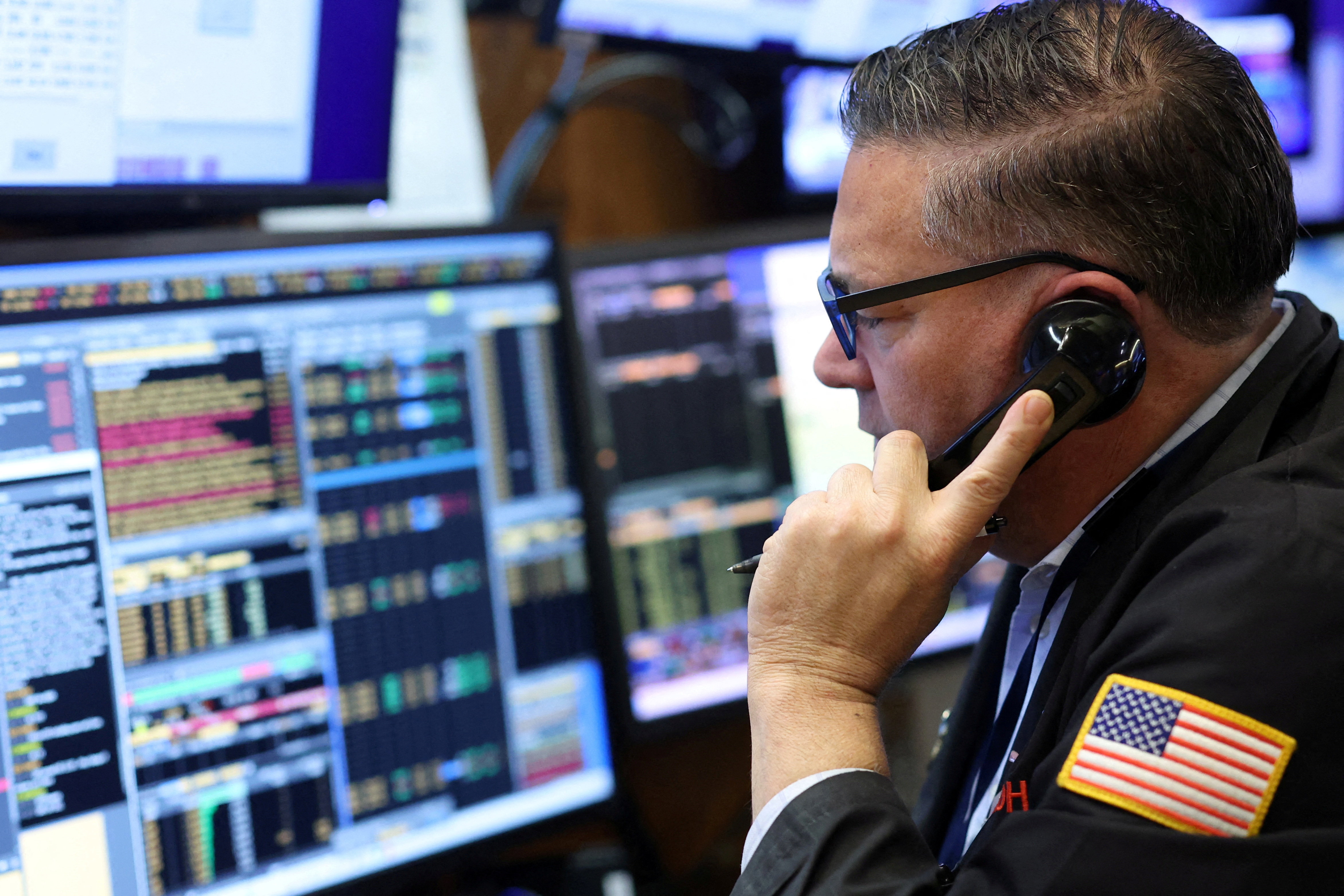 FILE PHOTO: A trader works on the trading floor at the New York Stock Exchange (NYSE) in New York City