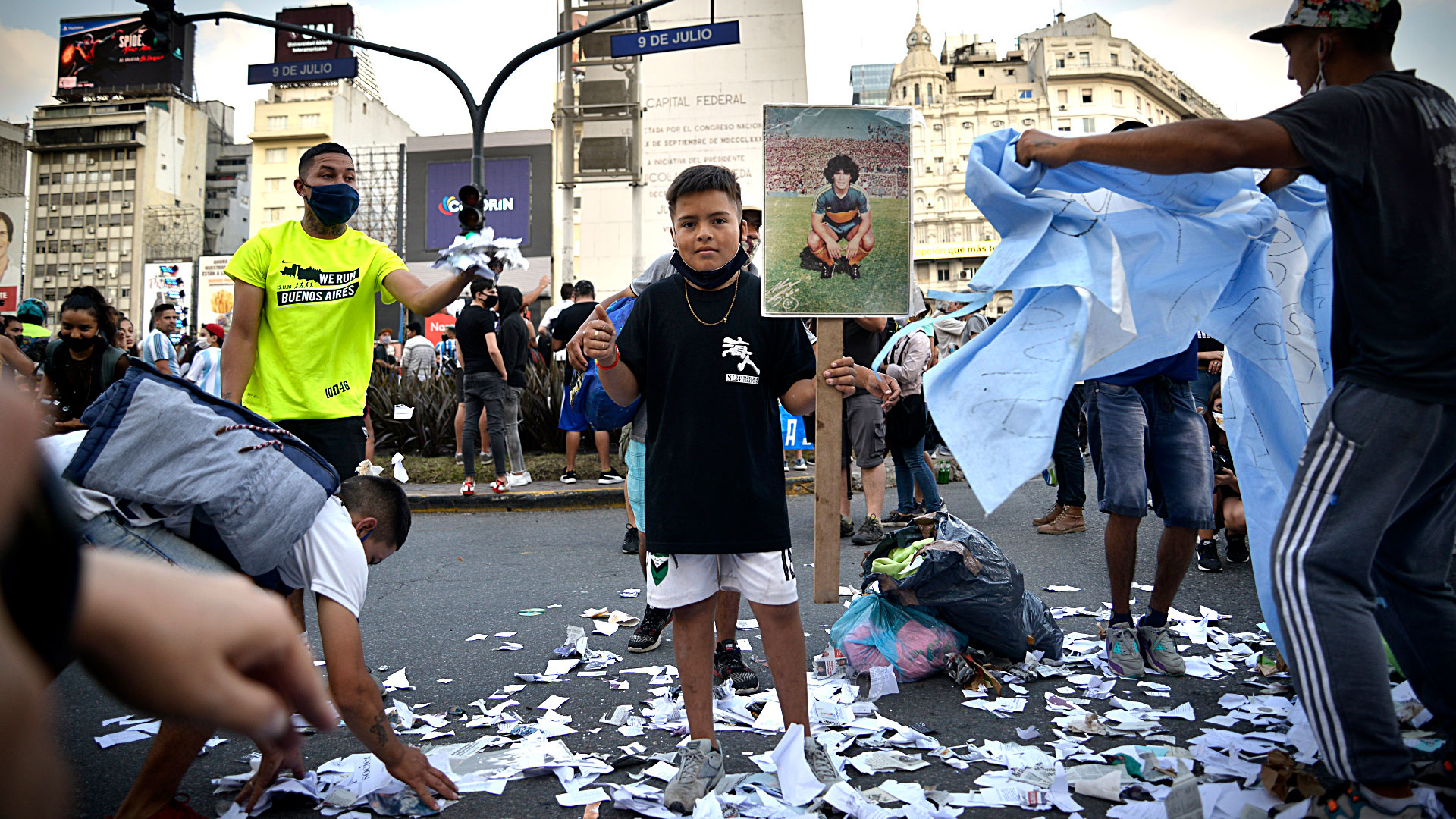 Los papelitos que lo bañaron en las salidas al campo de juego reposan en el suelo. Y un niño lamenta su partida junto a su imagen (Gustavo Gavotti)