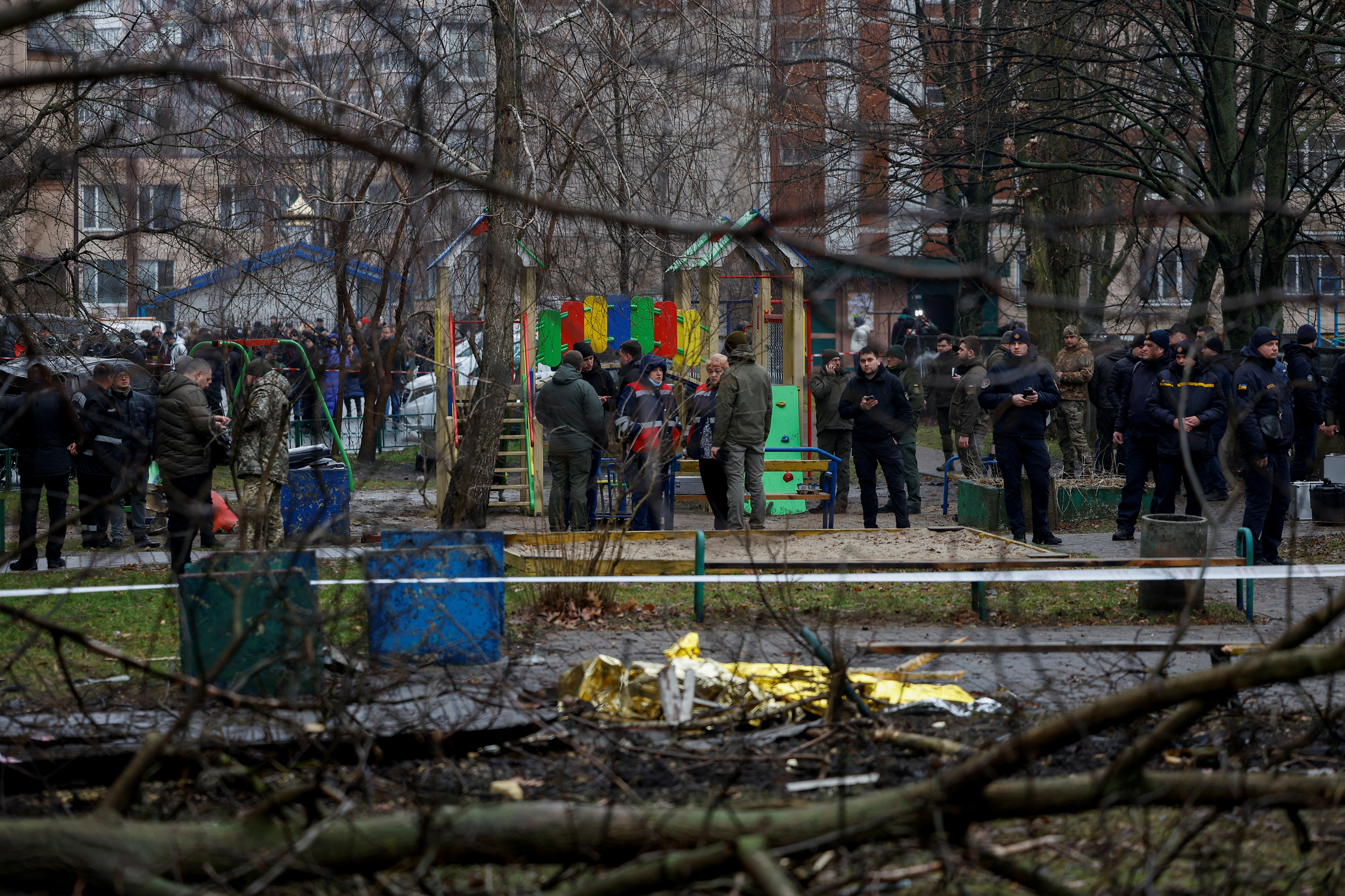 Un grupo de personas se reúne en el lugar del accidente de un helicóptero, en medio del ataque de Rusia a Ucrania, en la ciudad de Brovary, en las afueras de Kyiv, Ucrania, el 18 de enero de 2023. REUTERS/Valentyn Ogirenko