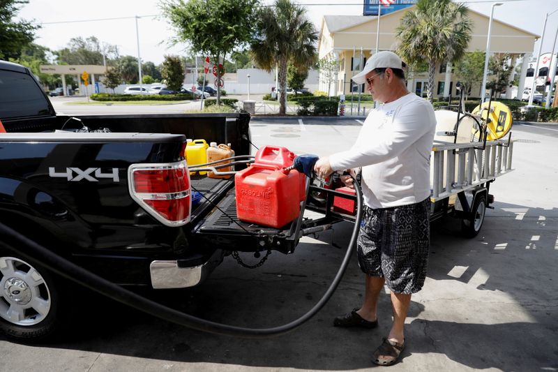 FOTO DE ARCHIVO: hombre cargando tanques de gasolina en Tampa, Florida