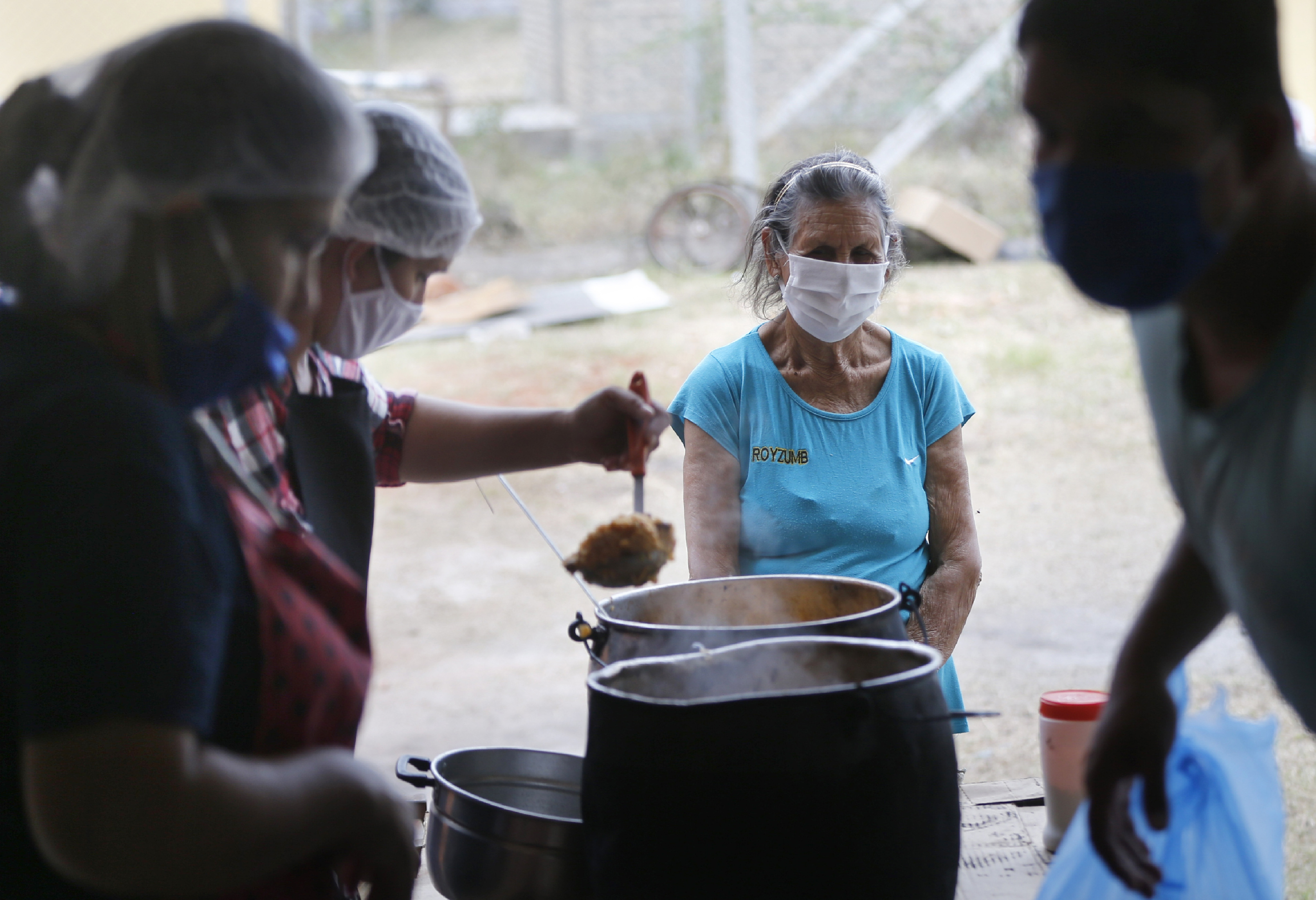Una mujer espera a recibir un plato de comida para ella y su familia en un comedor social durante la pandemia coronavirus en Luque, Paraguay (Foto: AP Foto/Jorge Sáenz)
