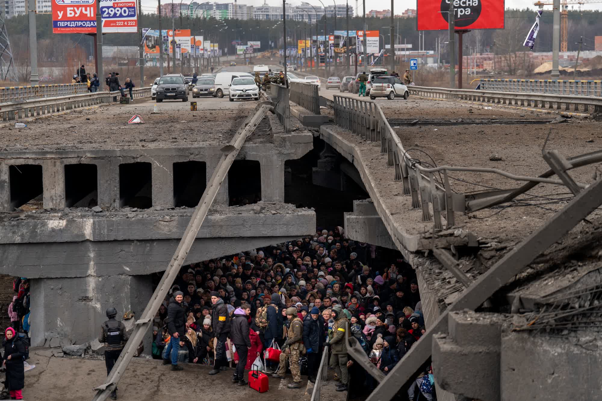 Cientos de personas que escapan de la guerra en Kyiv refugiadas bajo un puente destruido sobre el río Irpin en una imagen del 5 de marzo. (Emilio Morenatti/AP)