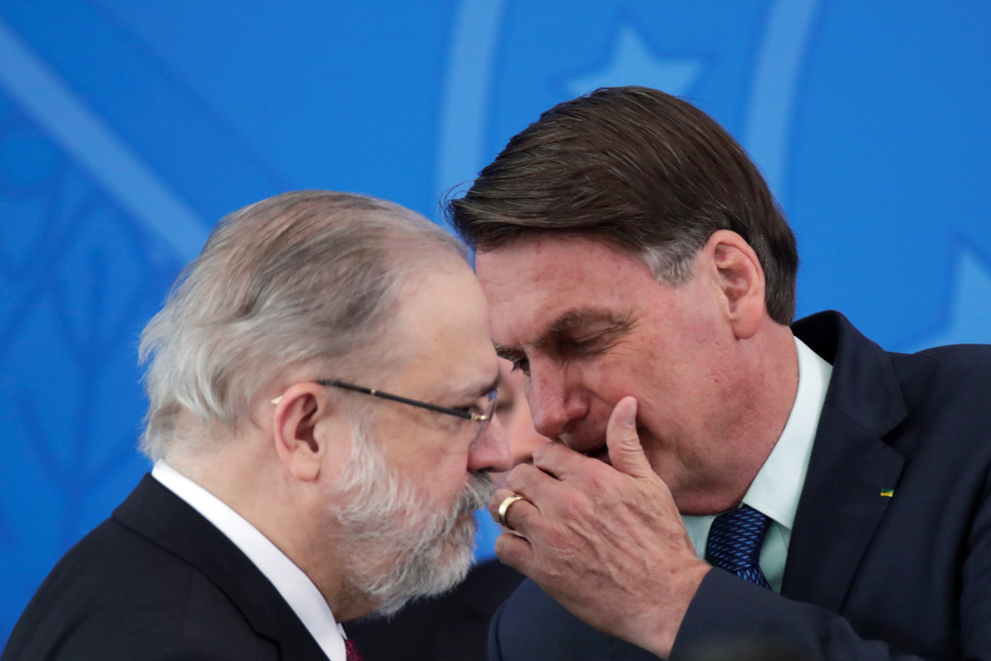 Jair Bolsonaro hablando con el procurador general Augusto Aras durante la ceremonia de jura de ministro de Salud, Nelson Teich en Brasilia. Ninguno de los dos usó máscaras faciales ni respetó la distancia social REUTERS/Ueslei Marcelino