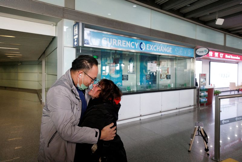 FOTO DE ARCHIVO. Varias personas se abrazan en la puerta de llegadas internacionales del Aeropuerto Internacional de Pekín Capital después de que China levantara el requisito de cuarentena por la enfermedad del coronavirus (COVID-19) para los viajeros entrantes en Pekín, China. 8 de enero de 2023. REUTERS/Thomas Peter