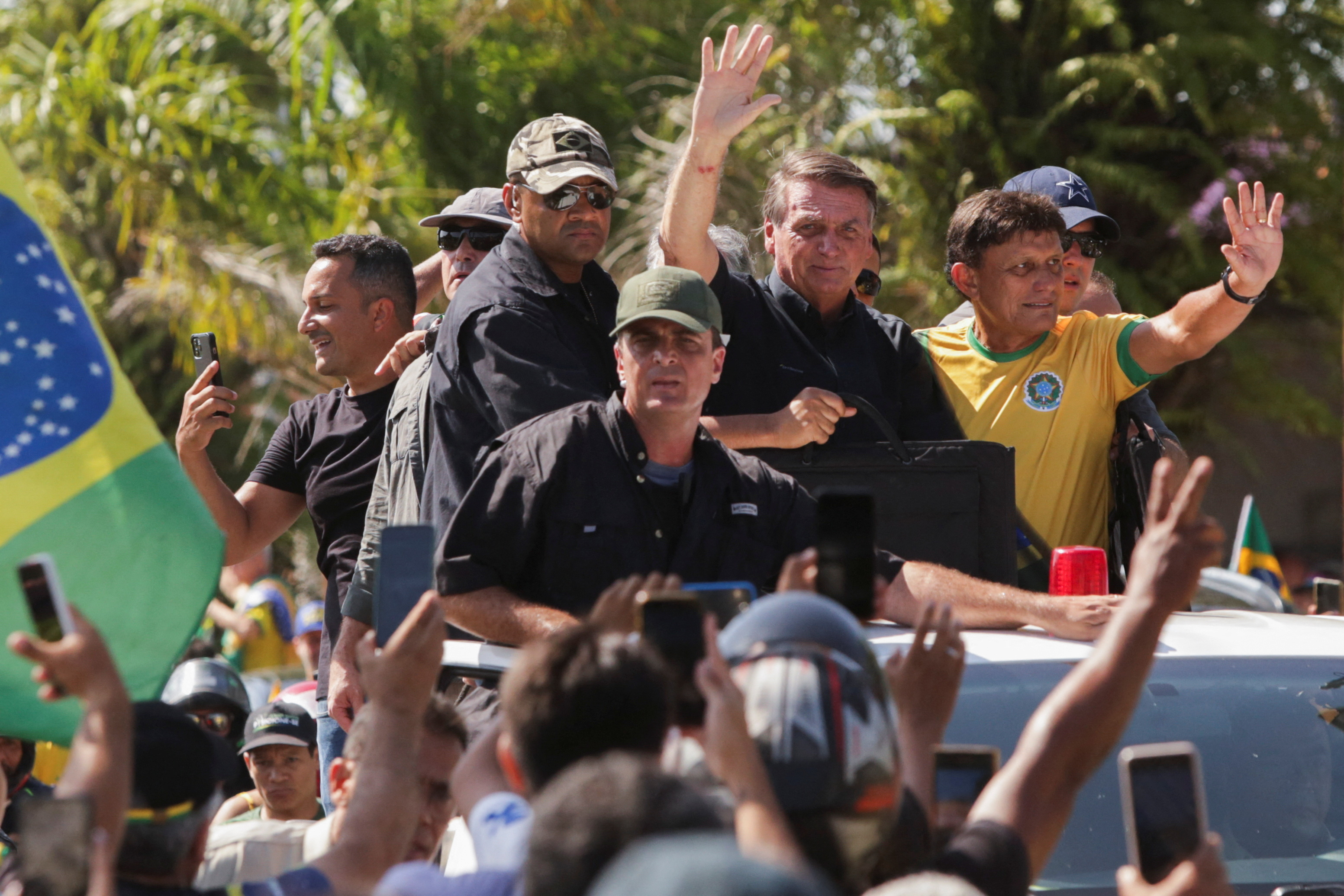 El presidente de Brasil, Jair Bolsonaro, saluda a sus simpatizantes mientras es protegido por un guardia de seguridad en un acto de campaña en Belem, Brasil, el 22 de septiembre de 2022.
