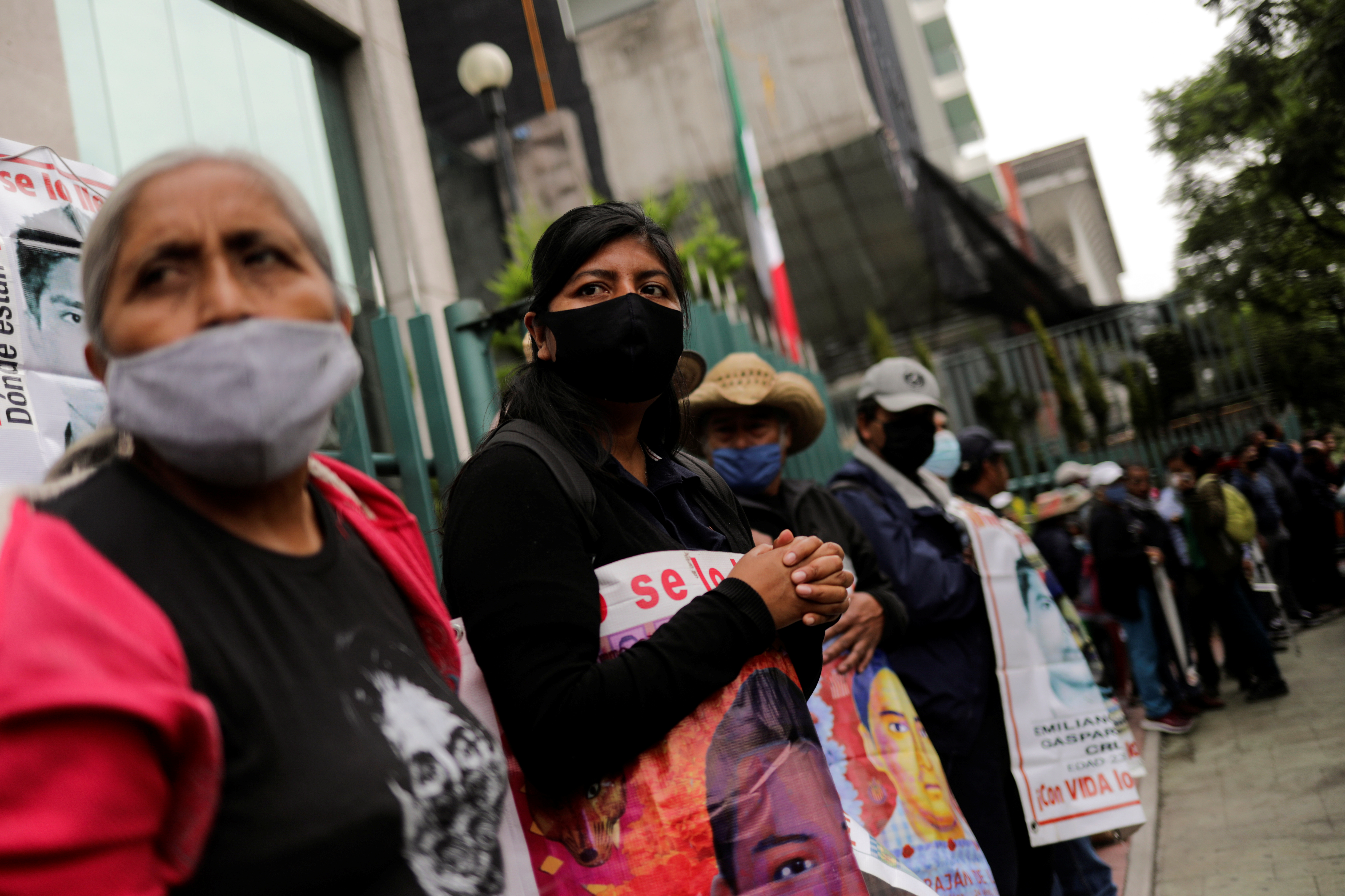 Familiares de estudiantes desaparecidos sostienen carteles durante una protesta frente a la Corte Suprema de Justicia, antes del sexto aniversario de la desaparición de 43 estudiantes de la Escuela de Formación de Maestros de Ayotzinapa, en la Ciudad de México, México 23 de septiembre de 2020.