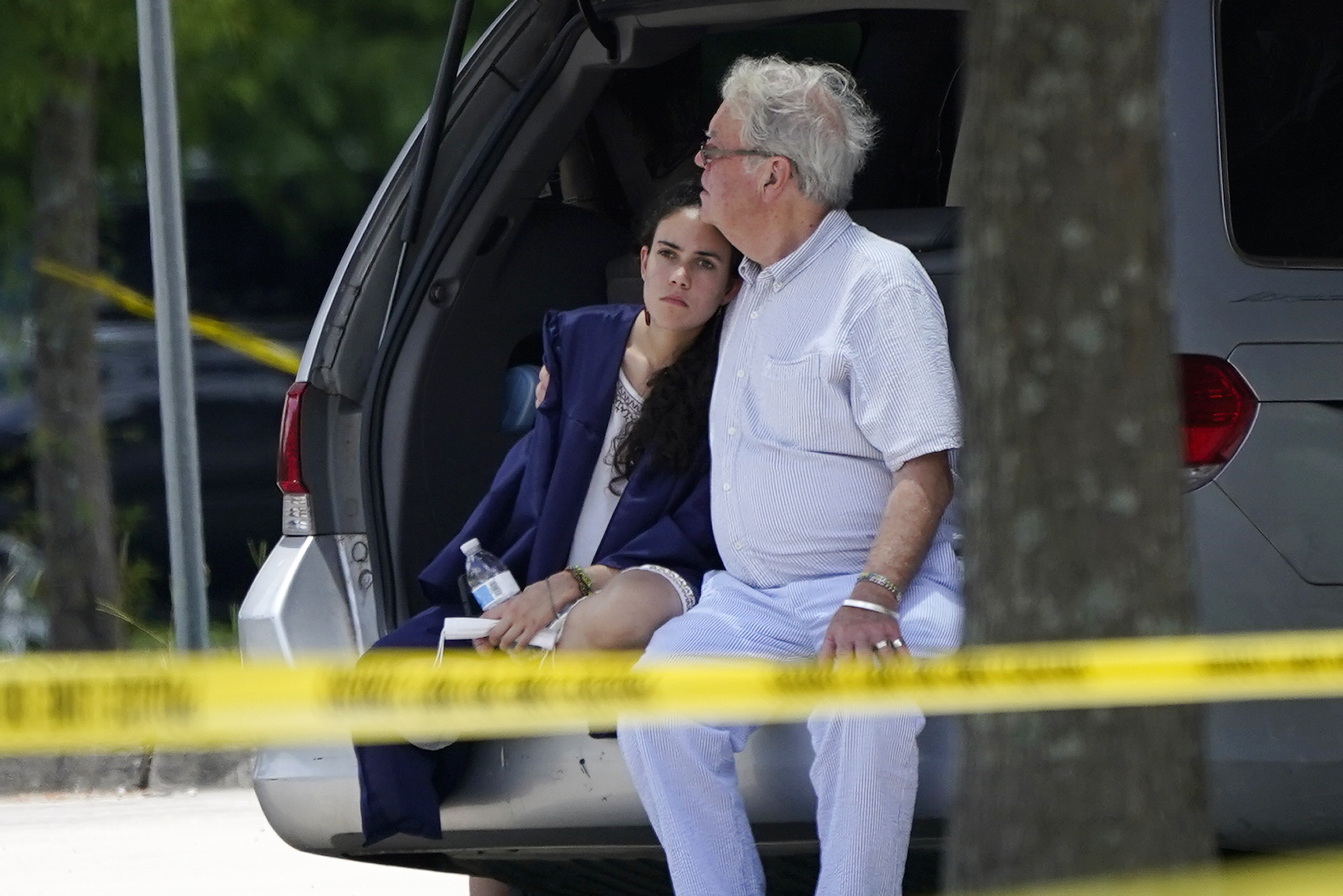 Un hombre consuela a una joven con una toga de graduación en la escena del crimen de un tiroteo en la Universidad Xavier en Nueva Orleans (AP/Gerald Herbert)