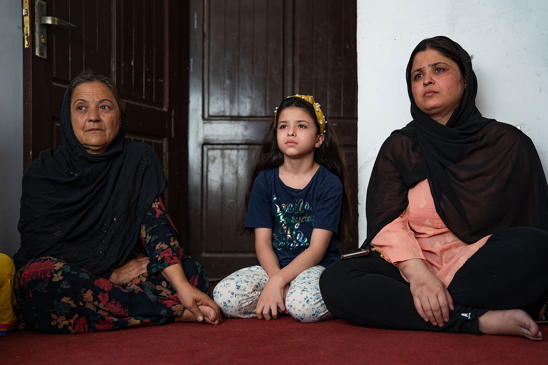 Tres generaciones, madre, hija y abuela, se sientan en el suelo de una pequeña habitación alquilada en Rawalpindi. 