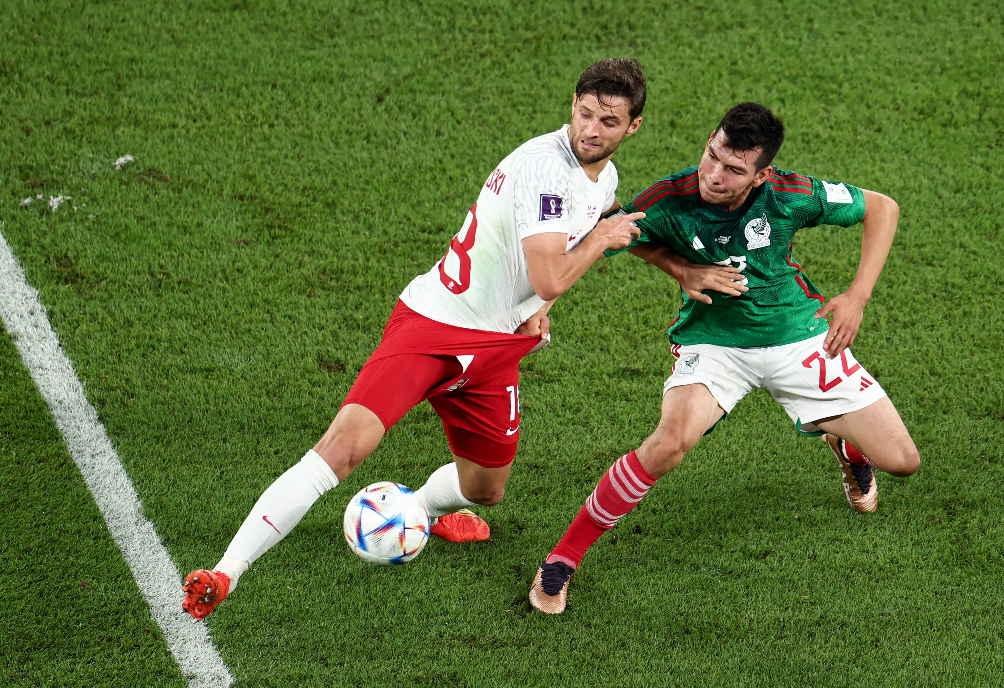 "Chucky" Lozano en la disputa por el balón con Bartosz Bereszynski. REUTERS/Marko Djurica