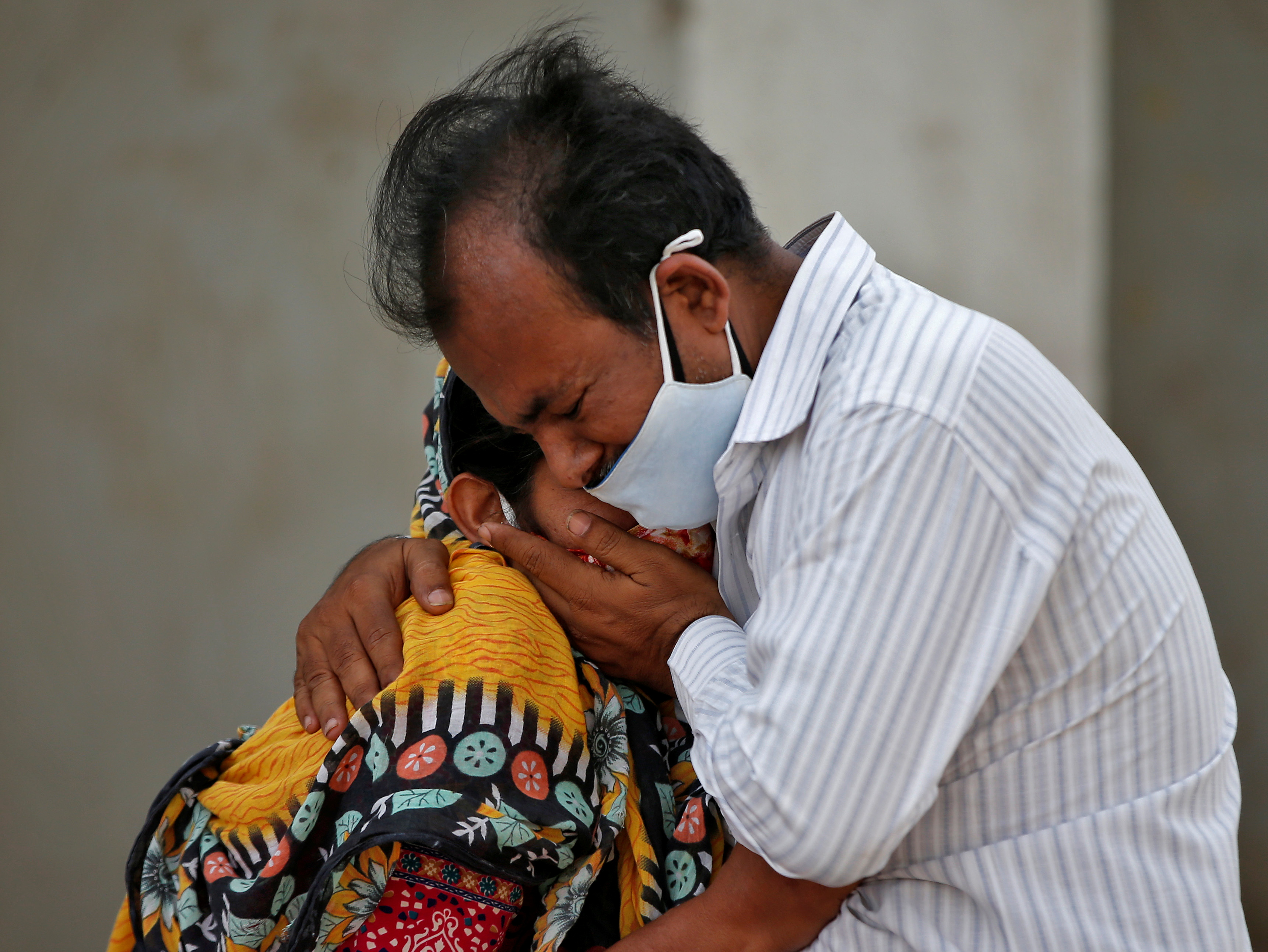 A woman is consoled by her relative after her husband died from the coronavirus disease (COVID-19) outside a COVID-19 hospital in Ahmedabad, India, April 26, 2021. REUTERS/Amit Dave