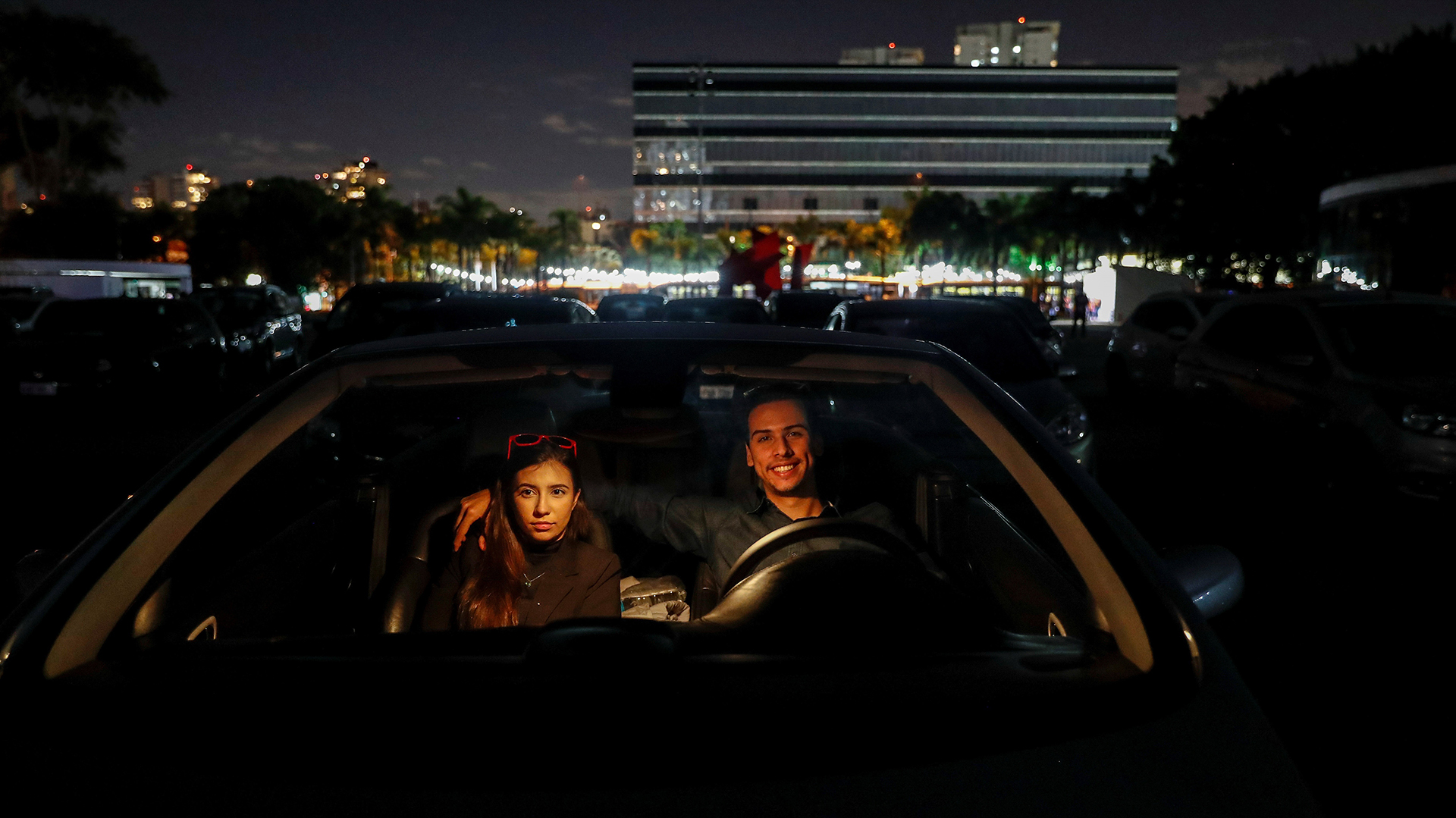 Una pareja a bordo de su vehículo mira una película en un autocine este miércoles, en San Pablo (EFE/ Sebastião Moreira)