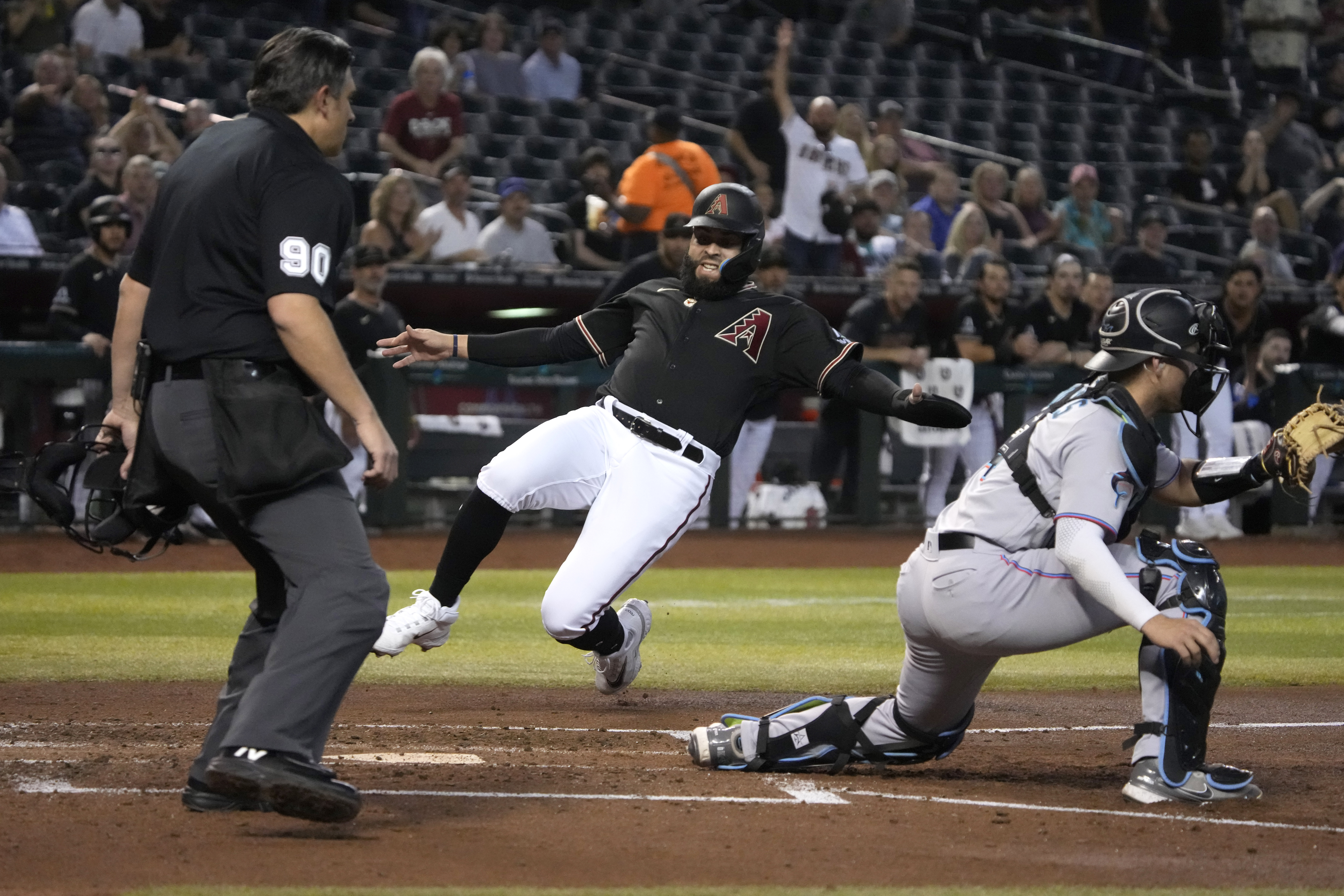 Emmanuel Rivera of the Arizona Diamondbacks scores in front of Miami Marlins catcher Nick Fortes after a double by Christian Walker in the fourth inning of a game Monday, May 8, 2023. (AP Photo/Rick Scuteri)