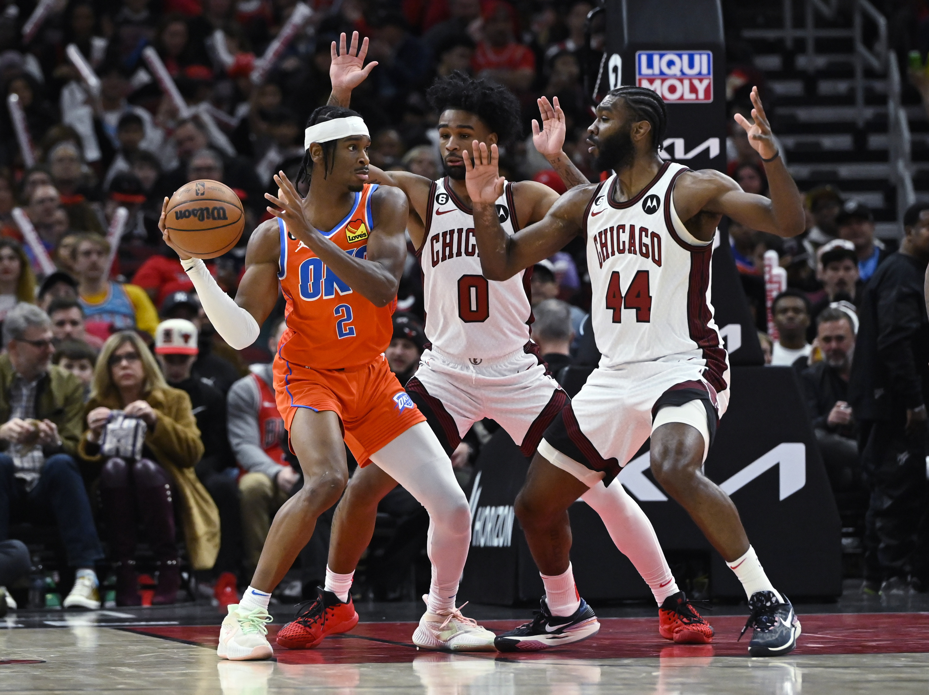Oklahoma City Thunder's Shai Gilgeous-Alexander (2) passes the ball away from Chicago Bulls' Coby White (0) and Patrick Williams (44) during the second half of an NBA basketball game, on Friday, January 13, 2023, in Chicago.  (AP Photo/Matt Marton)