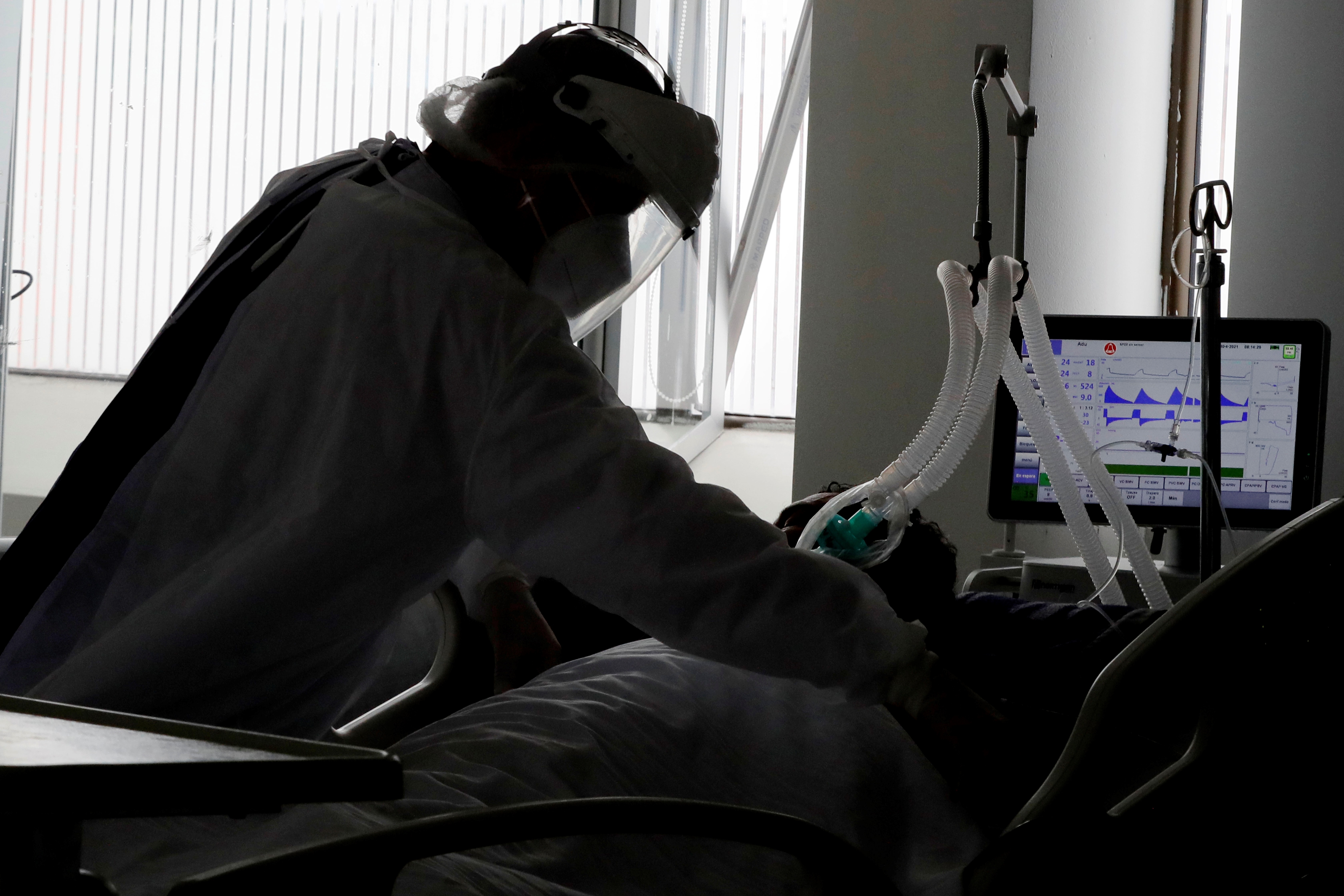 Una empleada de la salud atiende a un paciente en una unidad de cuidados intensivos para enfermos de covid-19 en Bogotá (Colombia), en una fotografía de archivo. EFE/Carlos Ortega
