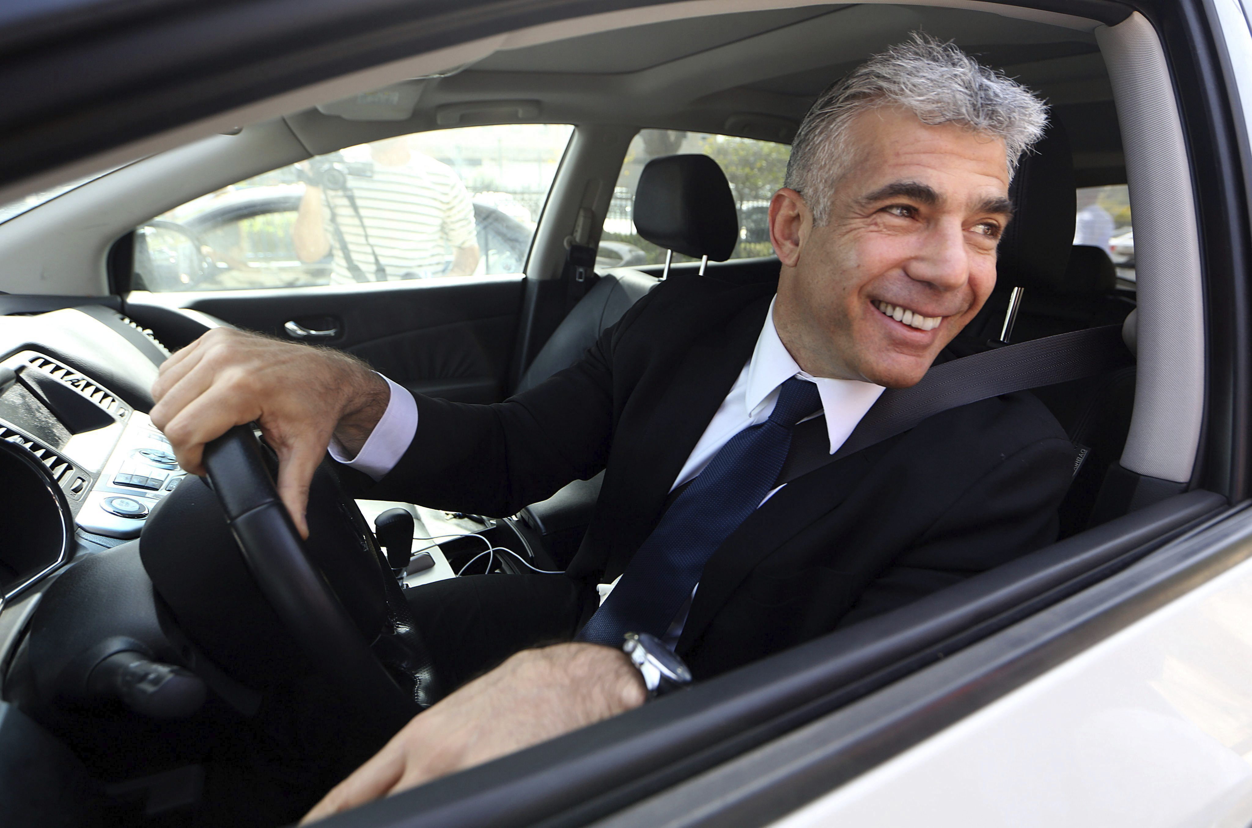 Lapid, de 58 años, conduce su automóvil y se presenta como un político versátil, capaz de dialogar y negociar con cualquiera (EFE/Abir Sultan)
