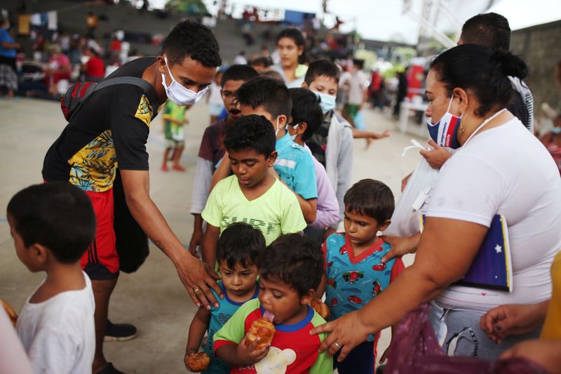 Niños migrantes venezolanos hacen fila dentro de un coliseo donde se ha instalado un campamento temporal, después de huir de su país debido a las operaciones militares (Foto: REUTERS/Luisa González)