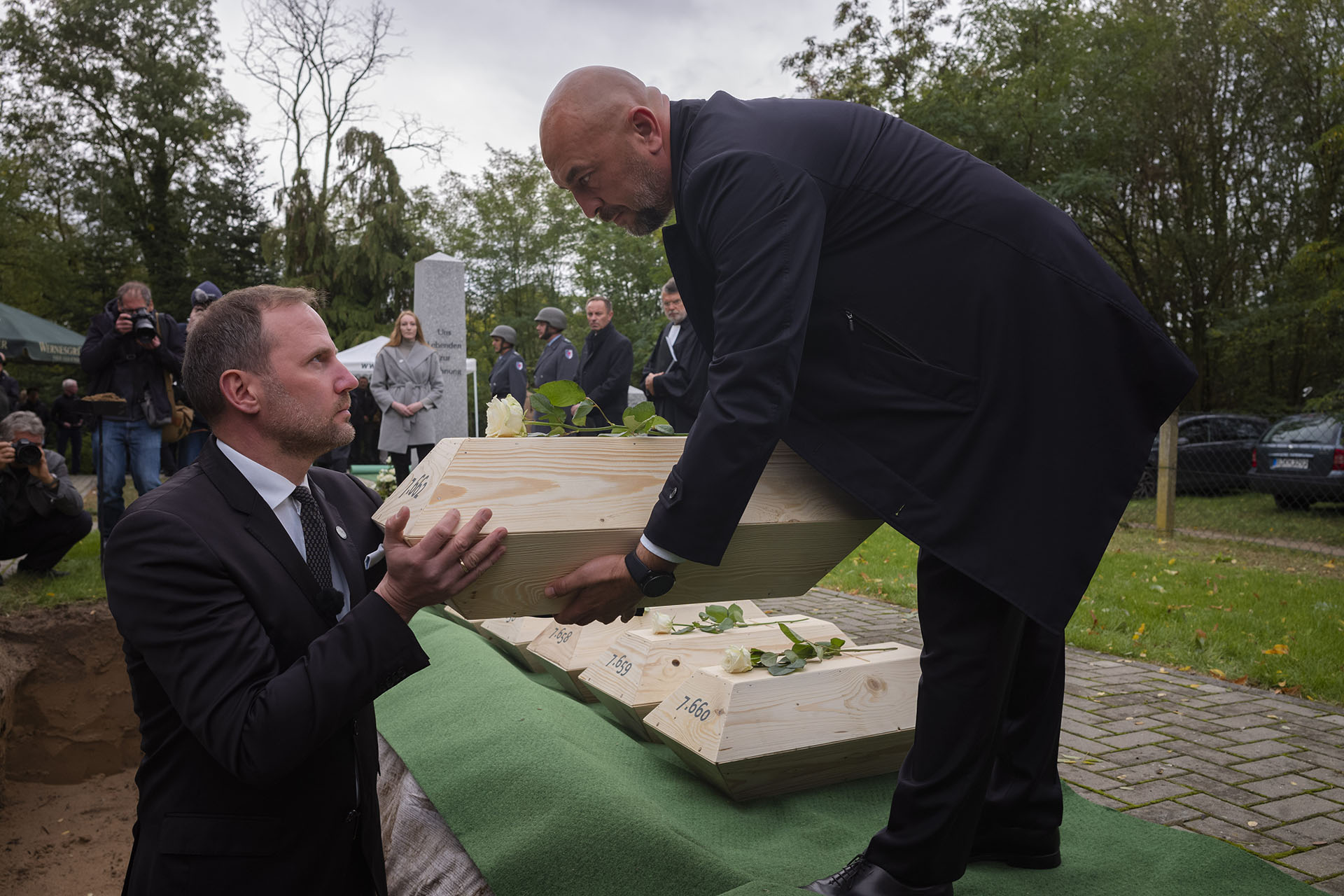 Albrecht Laue, izquierda, presidente de la Asociación para la Recuperación de los Caídos en Europa del Este, recibe un pequeño ataúd con los restos de un soldado caído alemán de la Segunda Guerra Mundial de Yaroslav Zhilkin, derecha, presidente de Organización de la Memoria Popular de la Unión Ucraniana, durante una ceremonia fúnebre en un sitio conmemorativo, en Wuhden, Alemania (Foto AP / Markus Schreiber)