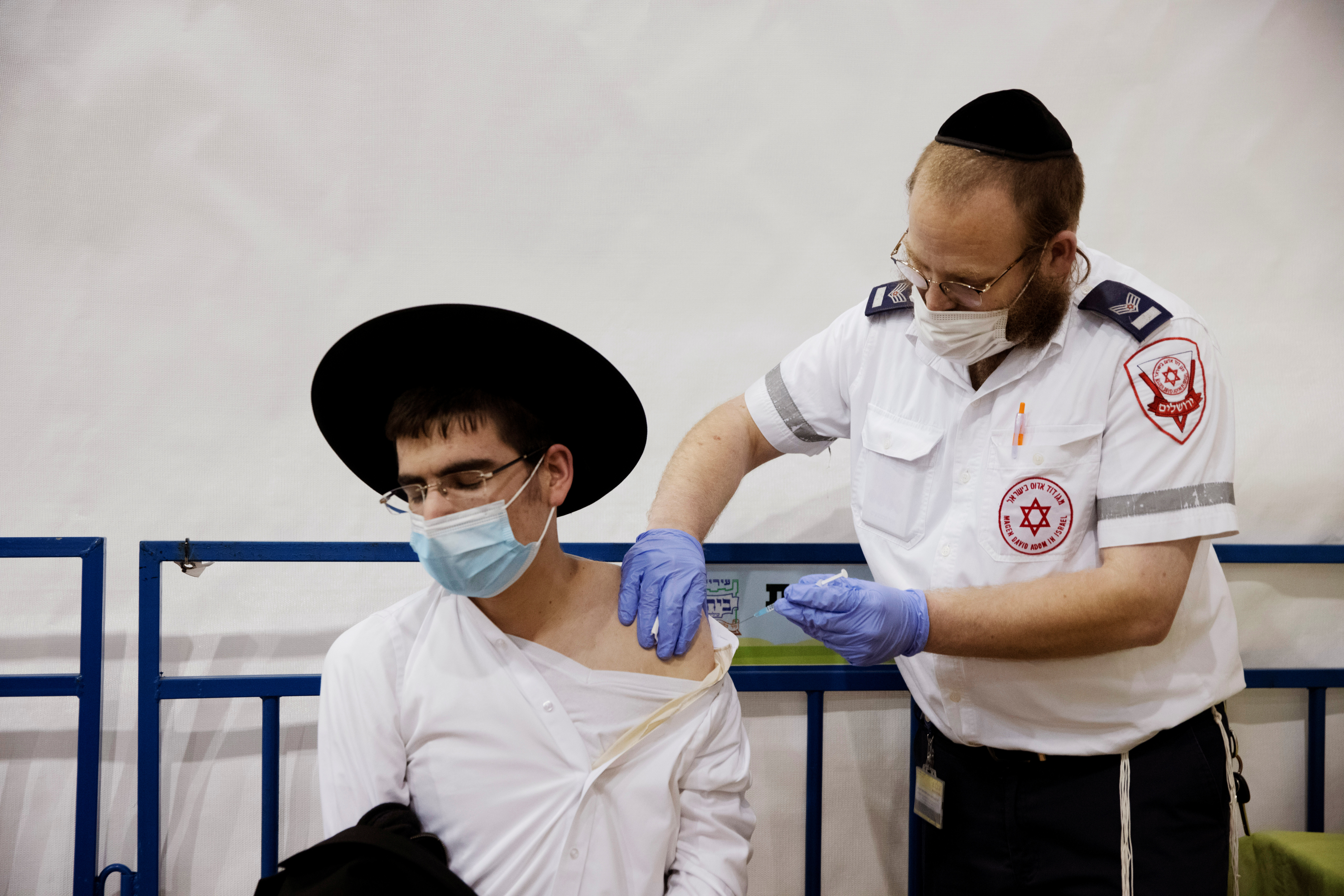 Un hombre judío ultraortodoxo recibe una vacuna contra el COVID-19 en un centro de vacunación temporal en el asentamiento judío de Beitar Illit (REUTERS/Ronen Zvulun)