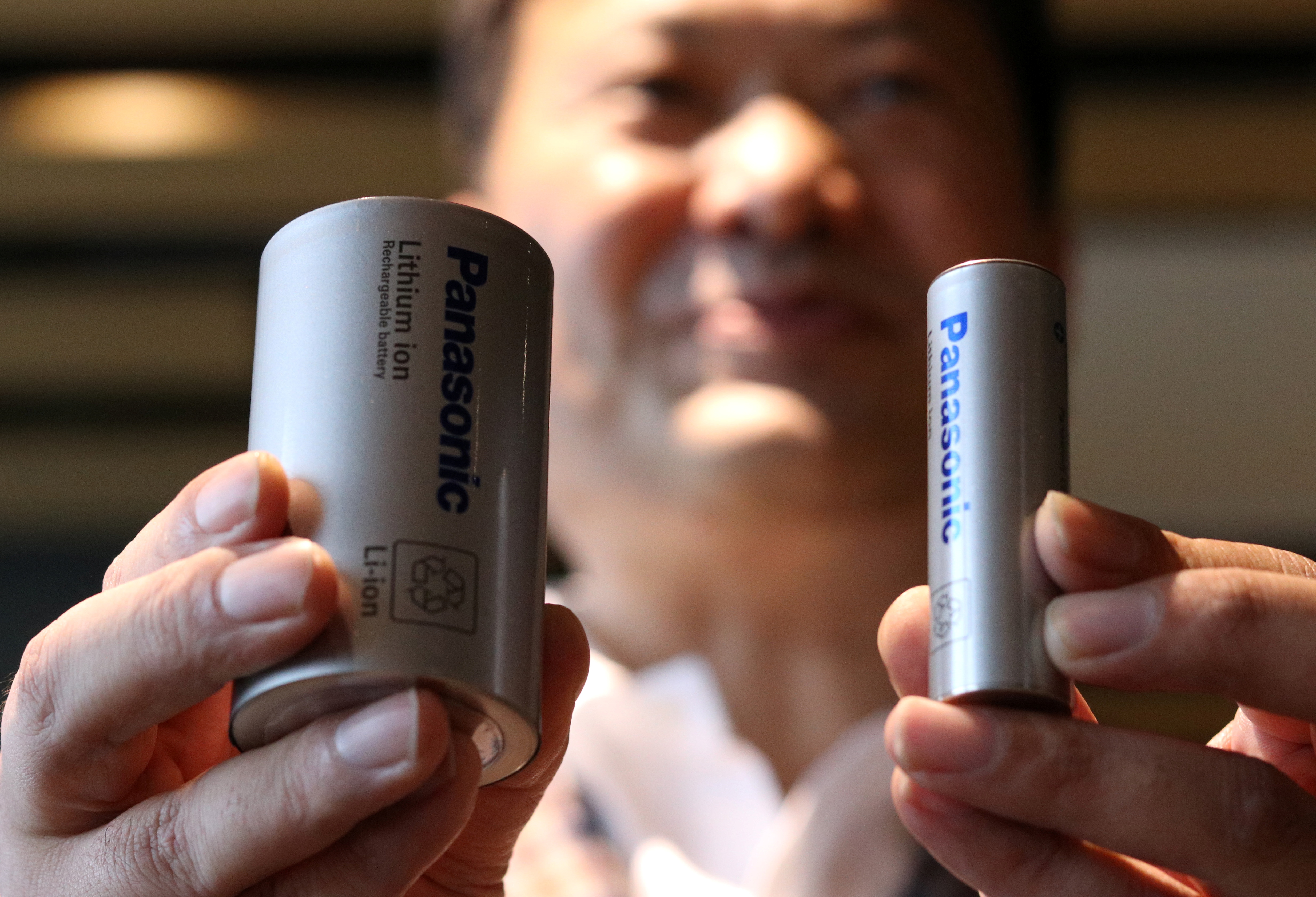 Kazuo Tadanobu, CEO de la compañía de energía de Panasonic, muestra un prototipo de una celda de batería 4680 y una 2170 como la que le proveen a Tesla (REUTERS/Tim Kelly)