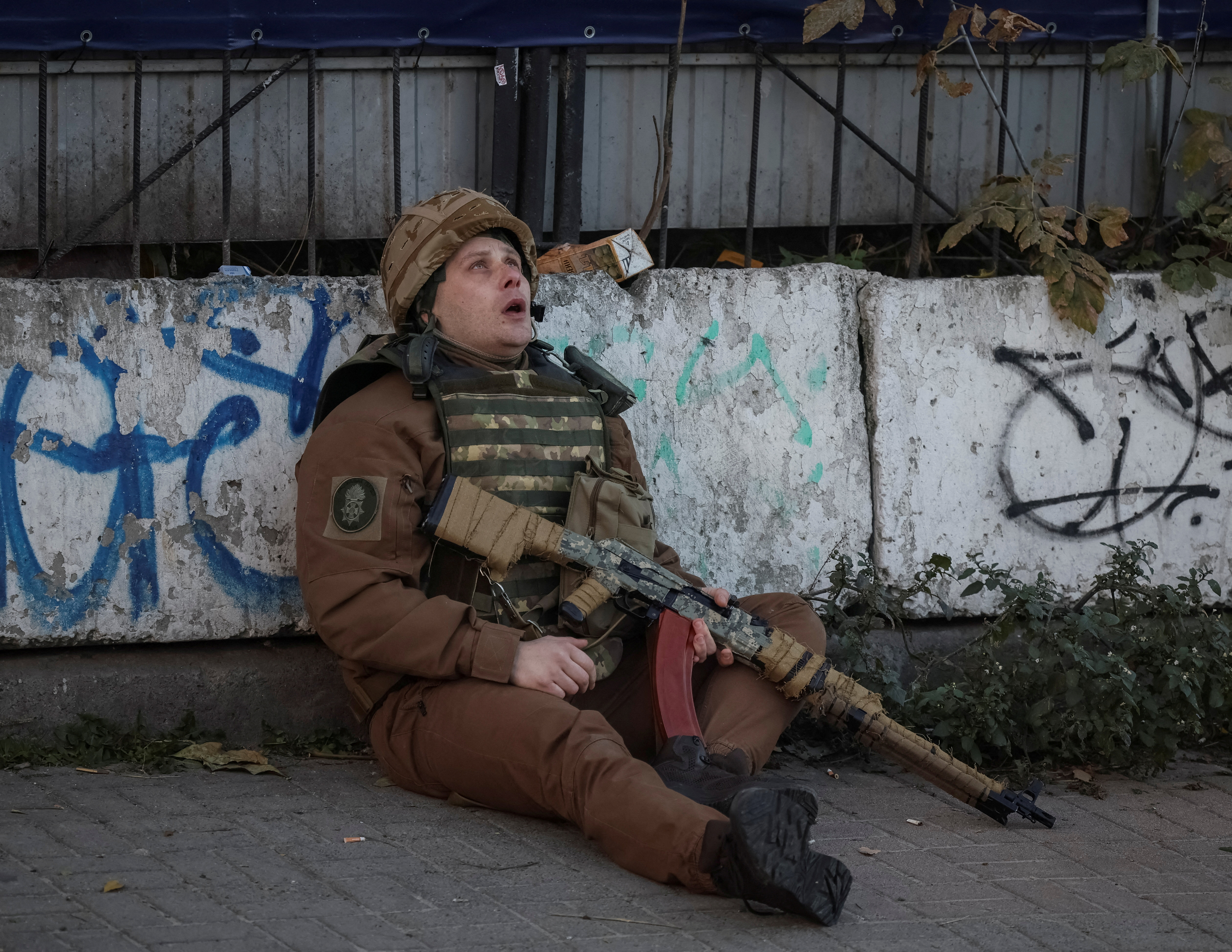 Un militar ucraniano se cubre cuando suena una sirena de ataque aéreo durante un ataque con drones (REUTERS/Gleb Garanich)