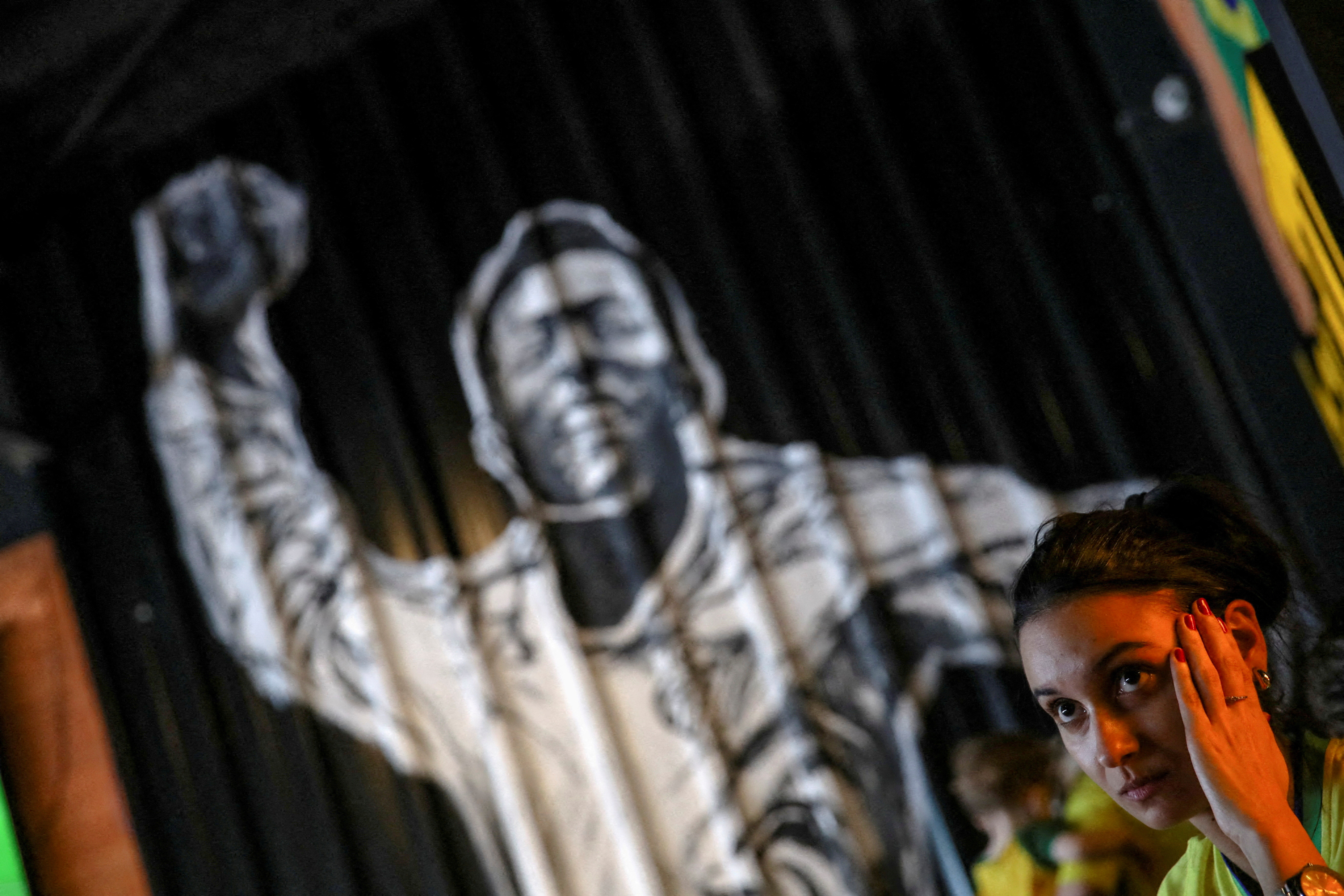 FILE PHOTO: A Brazilian fan reacts in front of a wall painting of former professional soccer player Pele as she watches the FIFA World Cup Qatar 2022 match between Brazil and Croatia at a bar in Santos, Brazil, December 9, 2022. REUTERS/Carla Carniel/File Photo